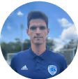 Ein männlicher Fußball Trainer auf einem Spielfeld mit seinen Spielern