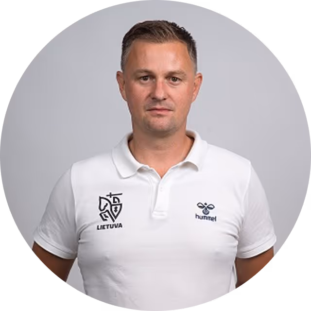 Man with short dark hair wearing a white polo shirt with Lithuania and Hummel logos standing against a gray background.