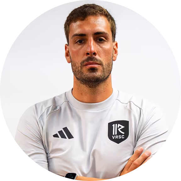 Bearded man in a white adidas training shirt with a VRSC crest, arms crossed