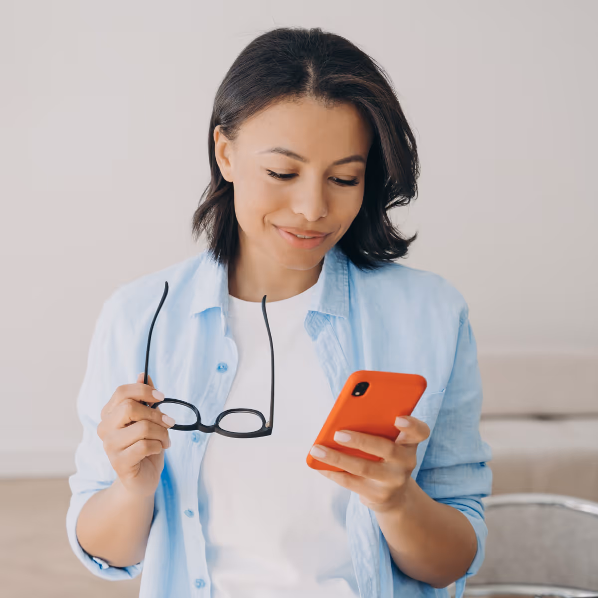 Donna sorridente che guarda lo smartphone