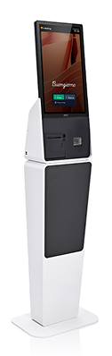 Tall white self-service kiosk with touchscreen displaying welcome message and menu options.