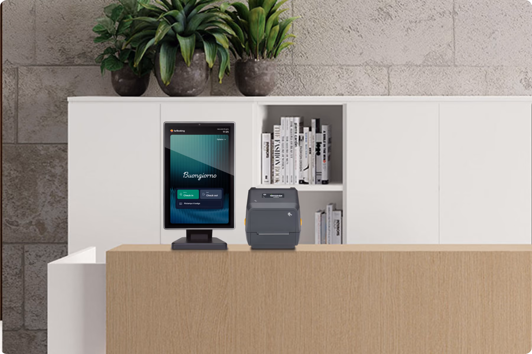 Reception digitale con scrivania in legno chiaro, schermo verticale che mostra un messaggio di benvenuto "Buongiorno" con opzioni di check-in e check-out, e una stampante accanto; sullo sfondo scaffali bianchi con libri e vasi con piante verdi.