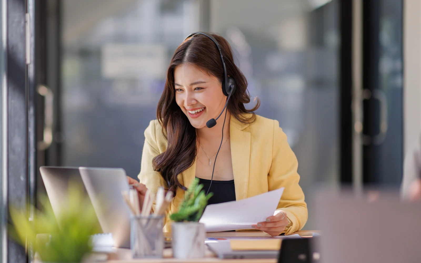 Customer support professional wearing a headset while working at a laptop.