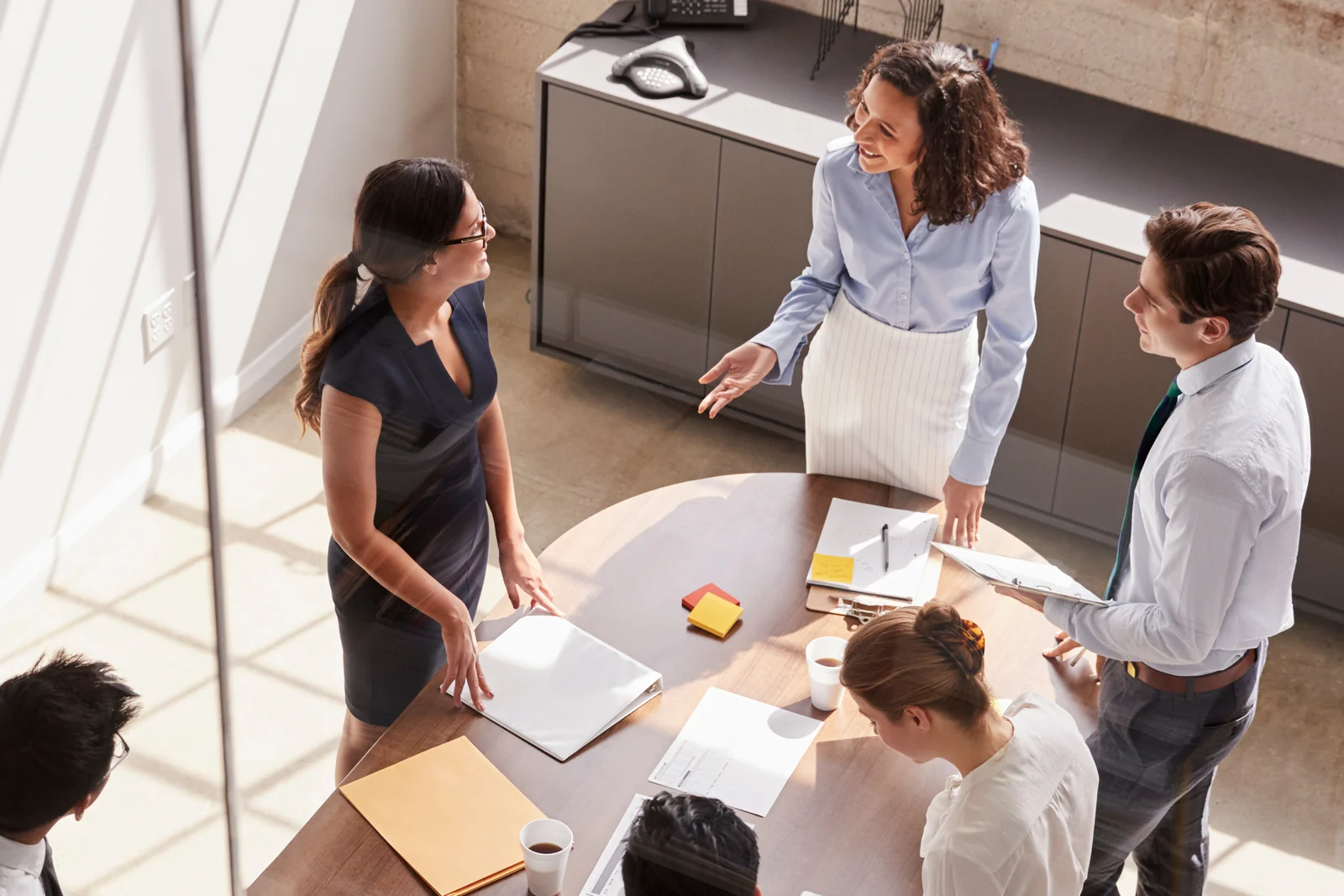 Colleagues discussing a project around a meeting table.