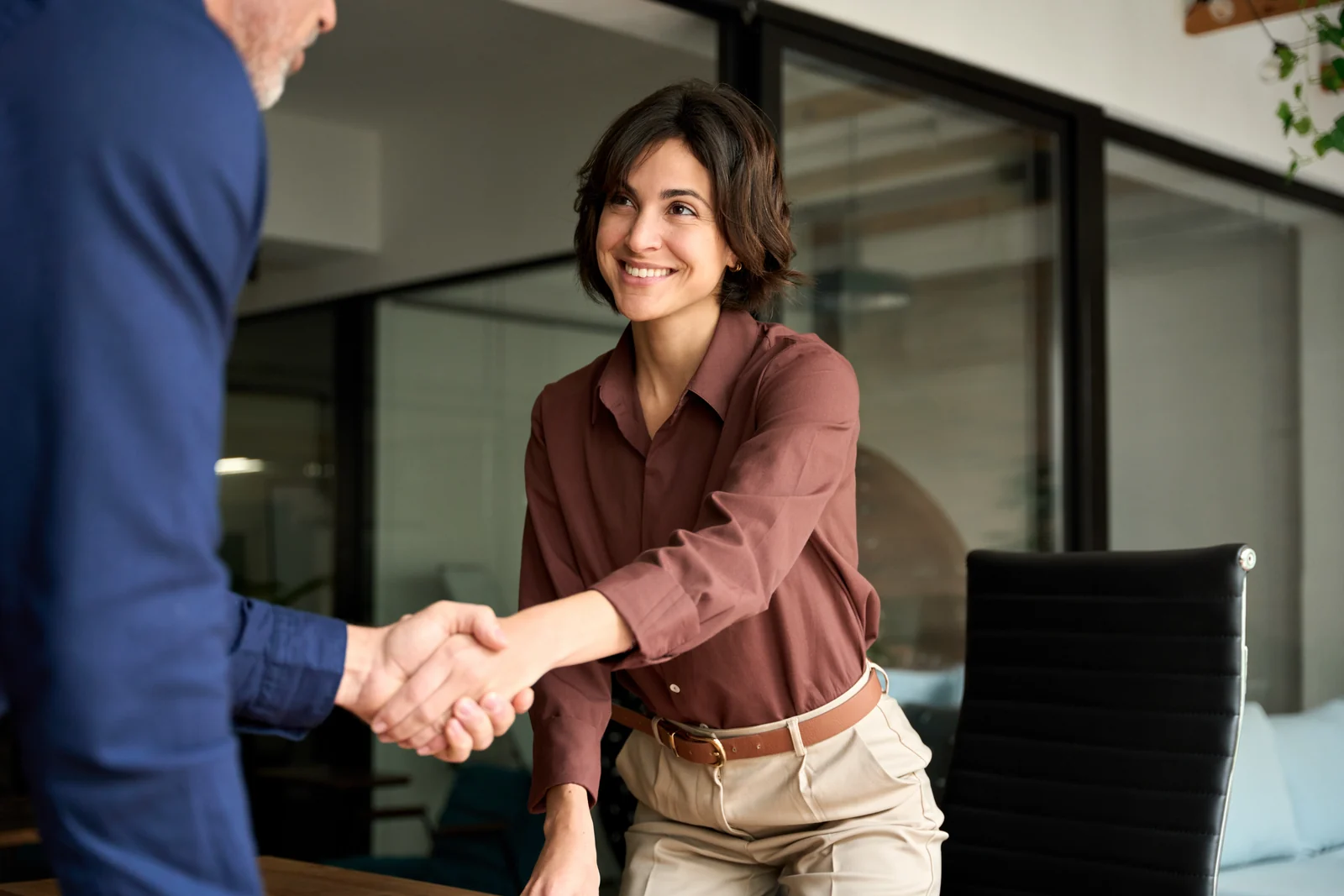 Two professionals shaking hands in an office.