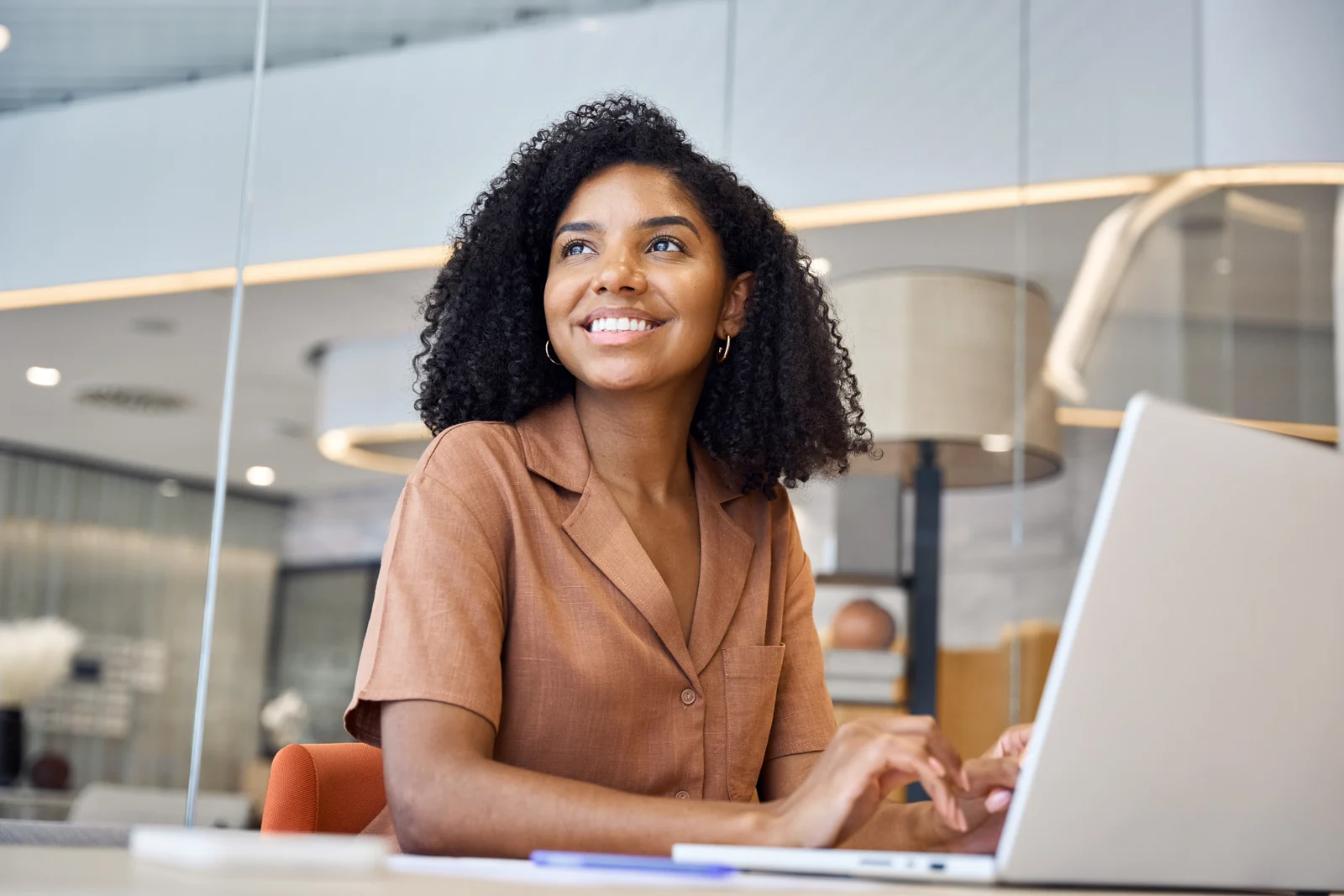 Professional working at a laptop in a bright office.