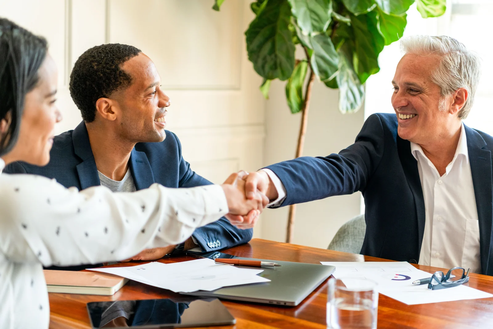 Professionals shaking hands during a meeting.