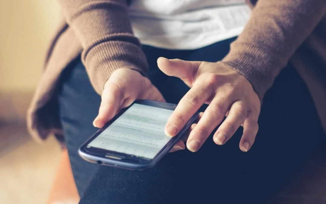 Customer Success: mulher mexendo em seu celular, provavelmente em um aplicativo de mensagens