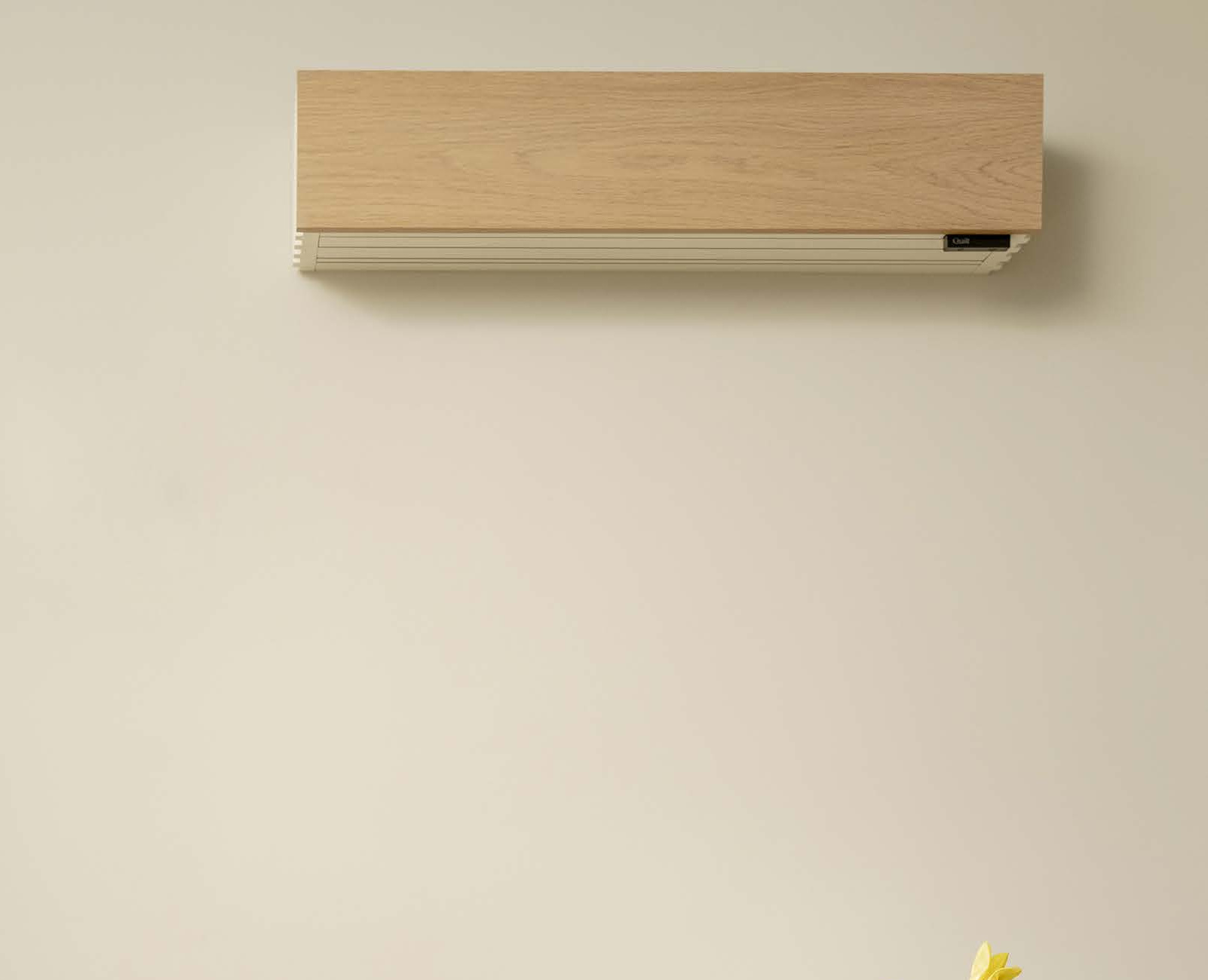 Wall-mounted air conditioner with a wood-textured front panel on a beige wall.