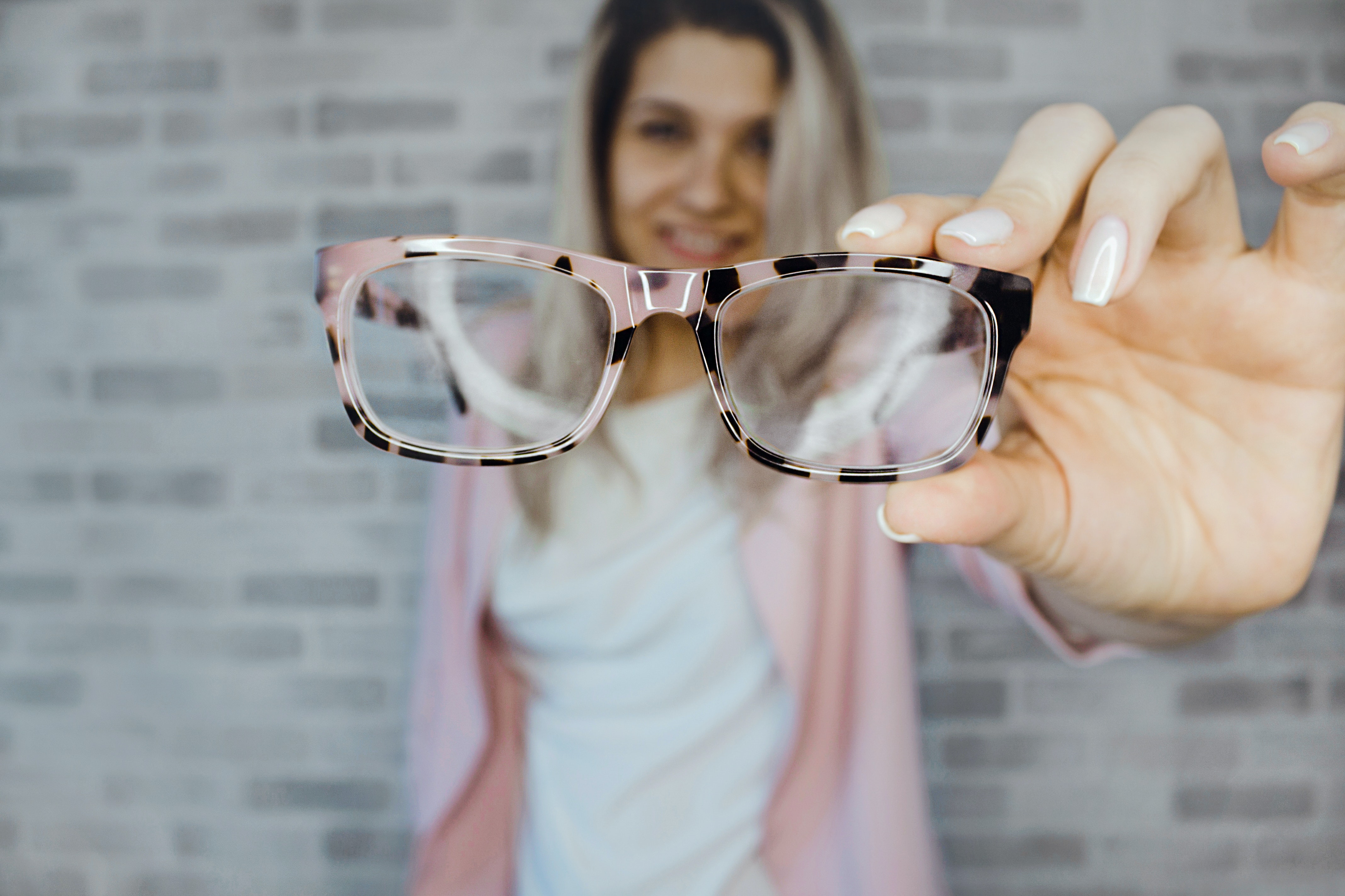 Lady holding optomology glasses up to demonstrate the industry challenges present in the optomology ophtalmic equipment industry