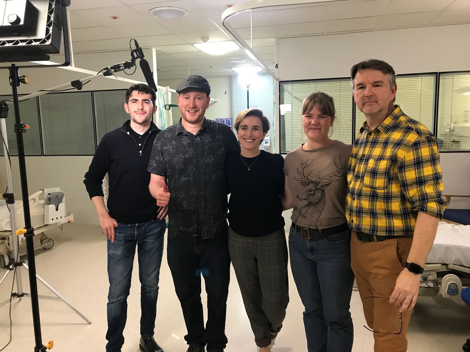 video production crew posing together on set in a studio environment