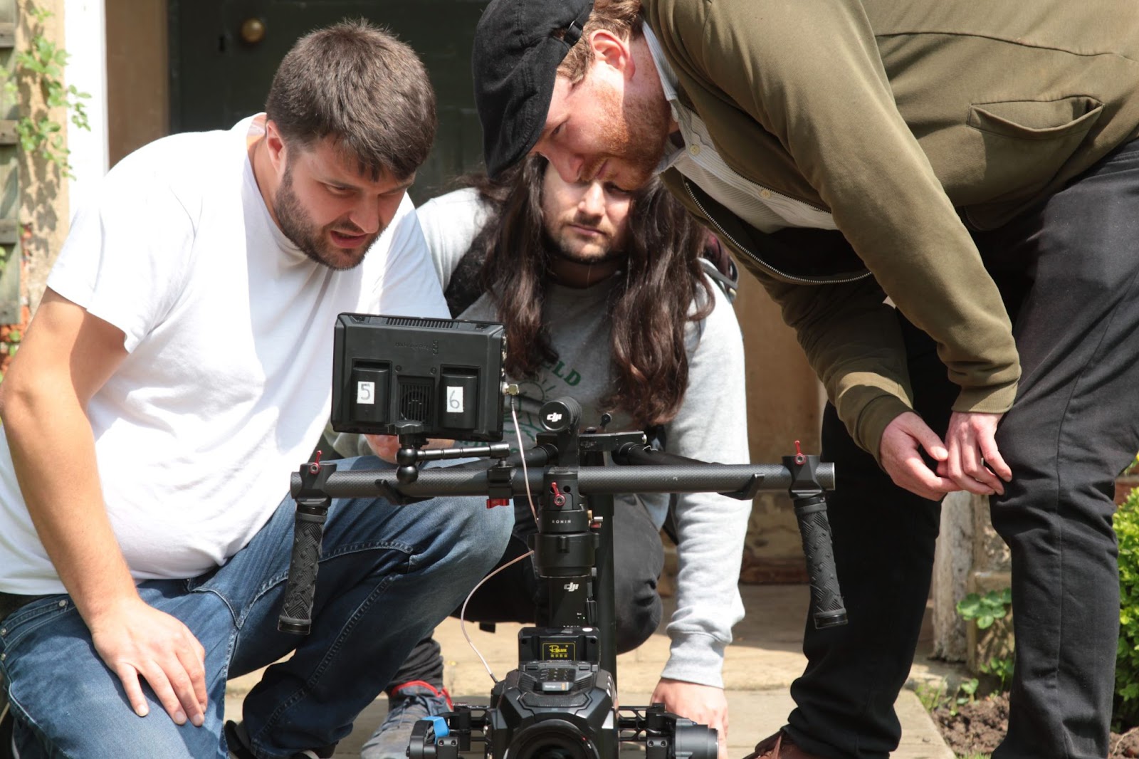 Two crew members setting up a camera outdoors