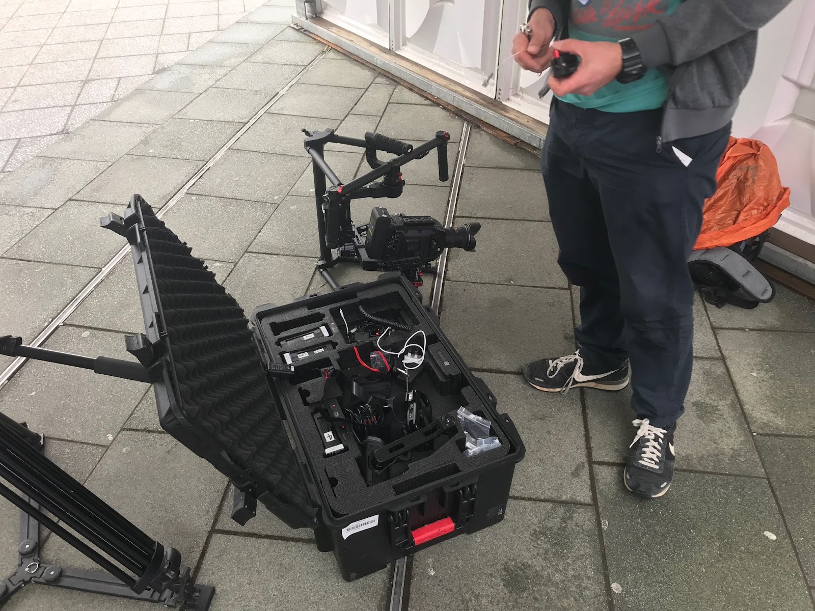 Person preparing video equipment from case outdoors