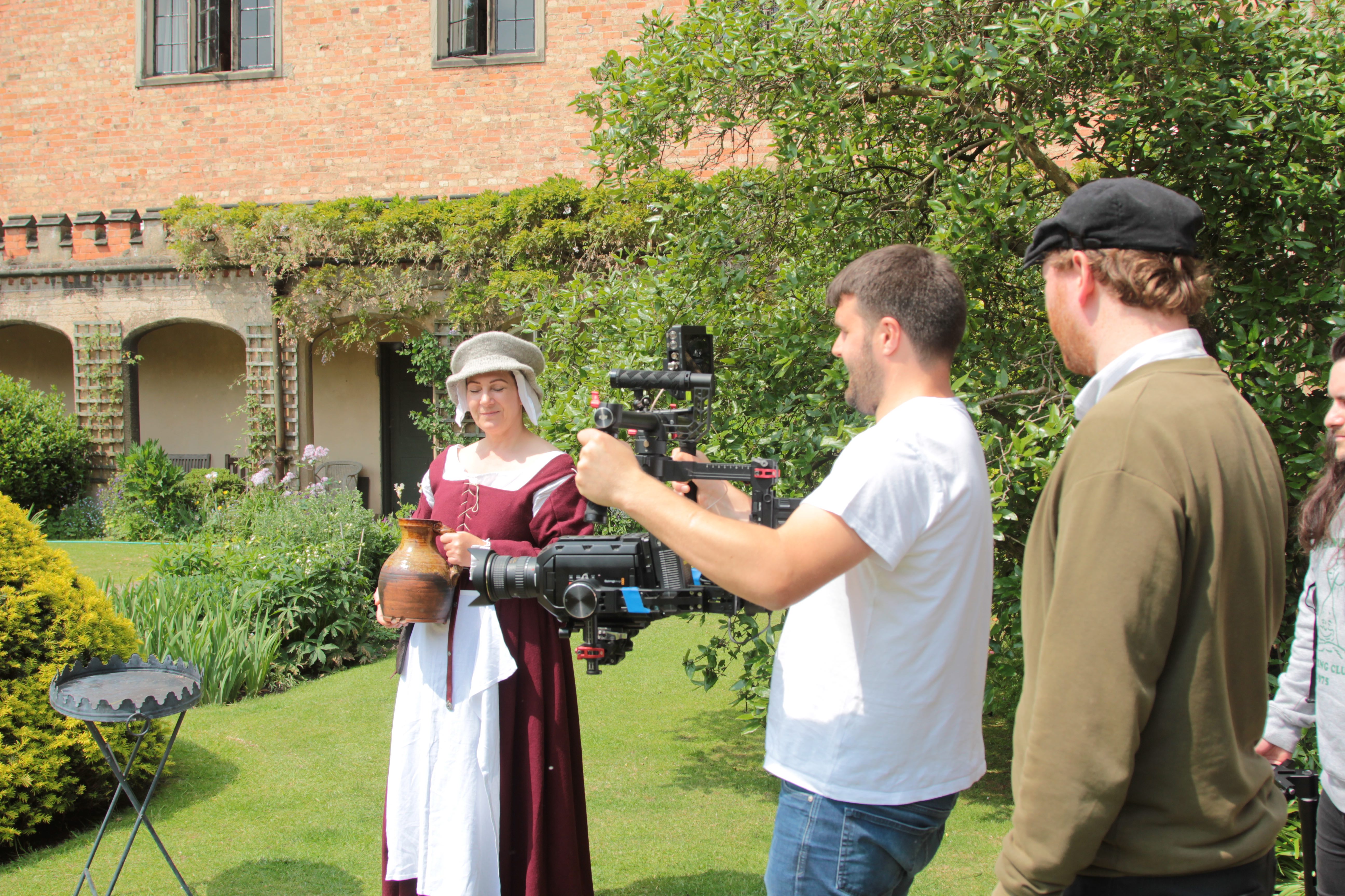 Film crew recording an outdoor scene with actors.