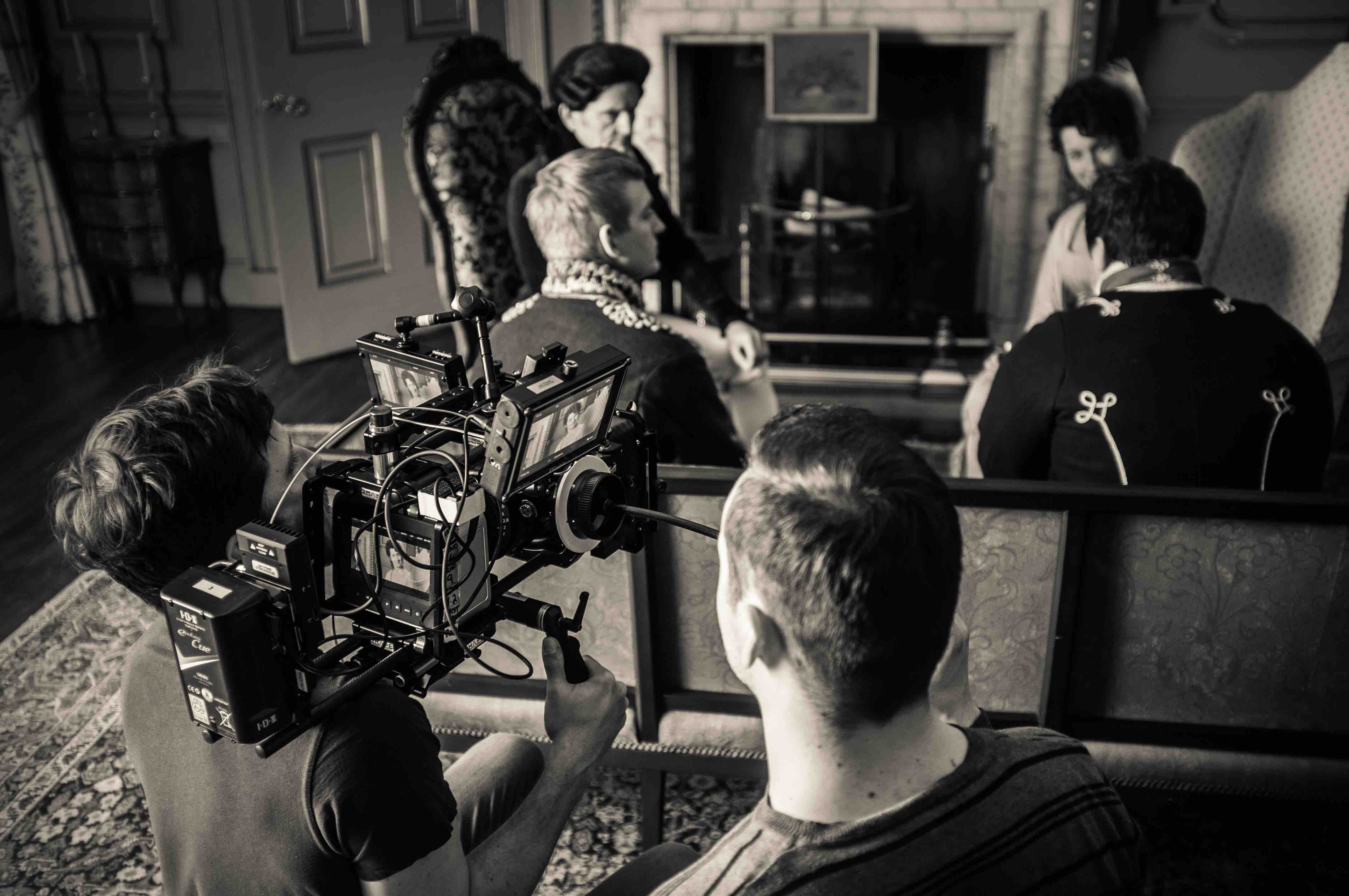 Film crew recording video scene indoors with professional camera.