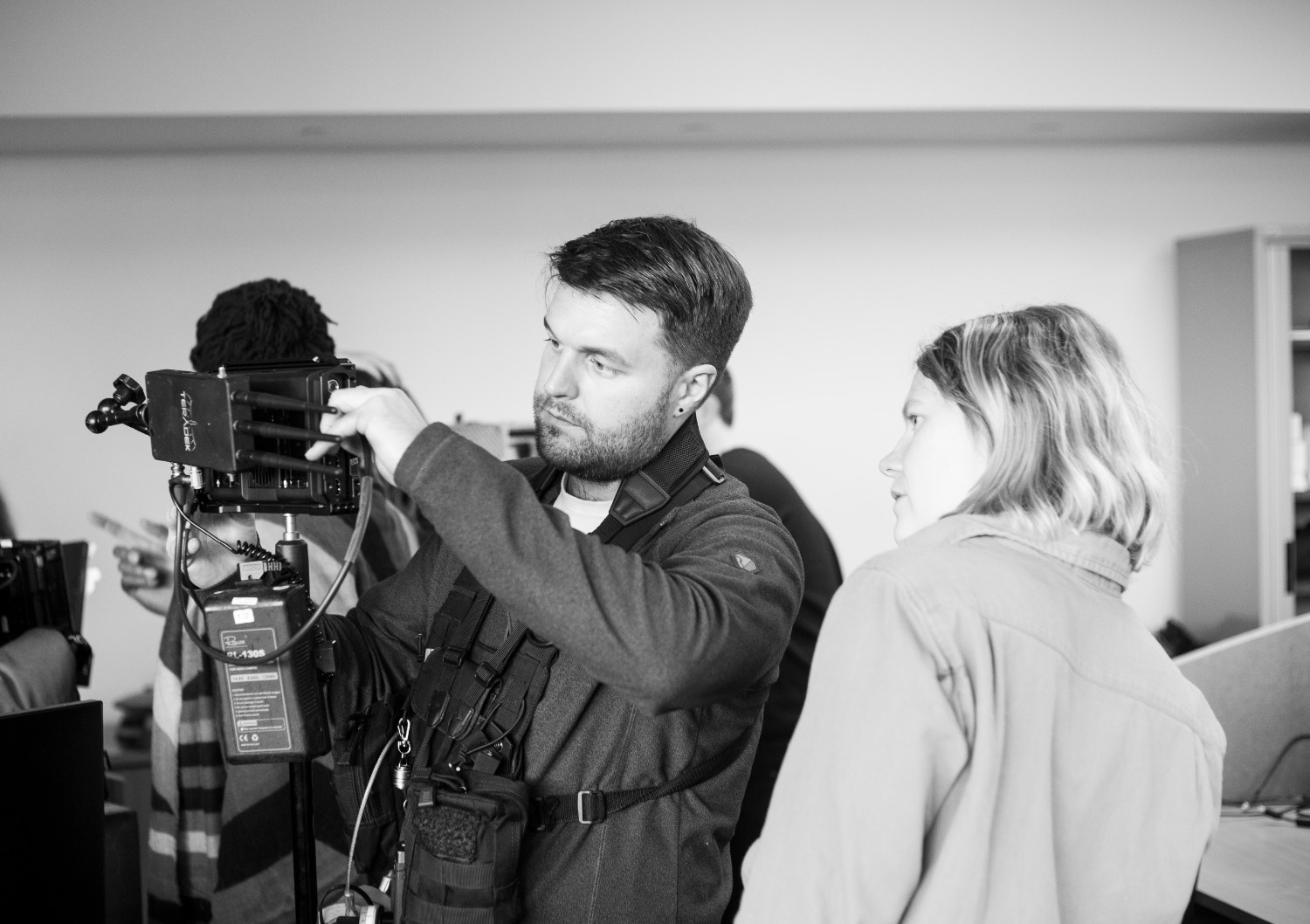 Videographer demonstrating camera setup during shoot.