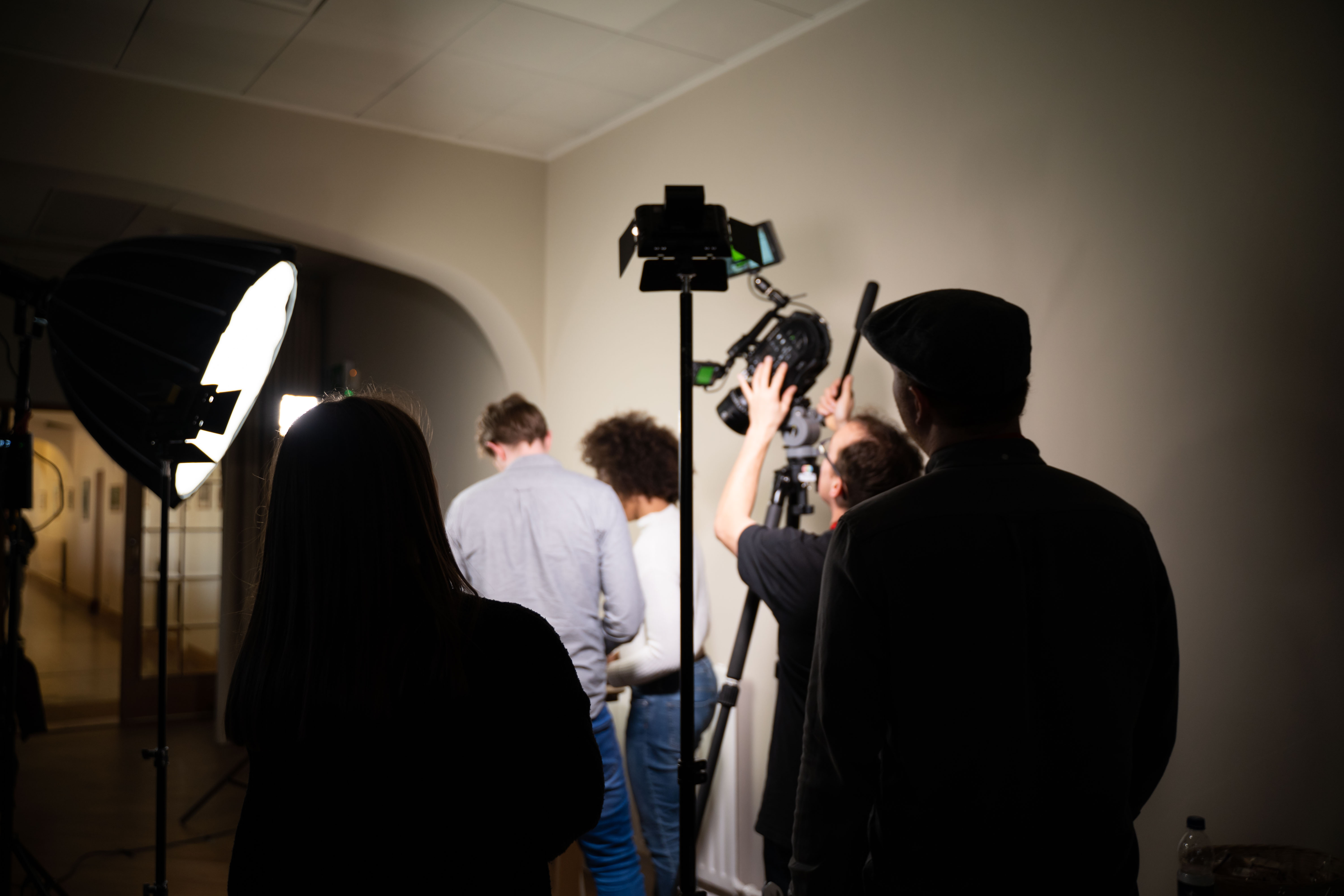 Film crew setting up camera and lights for a shoot.