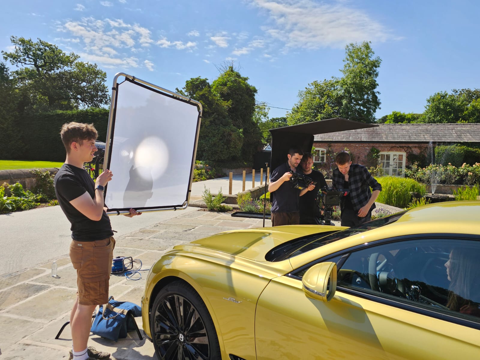 Film crew working with camera and lighting outdoors.