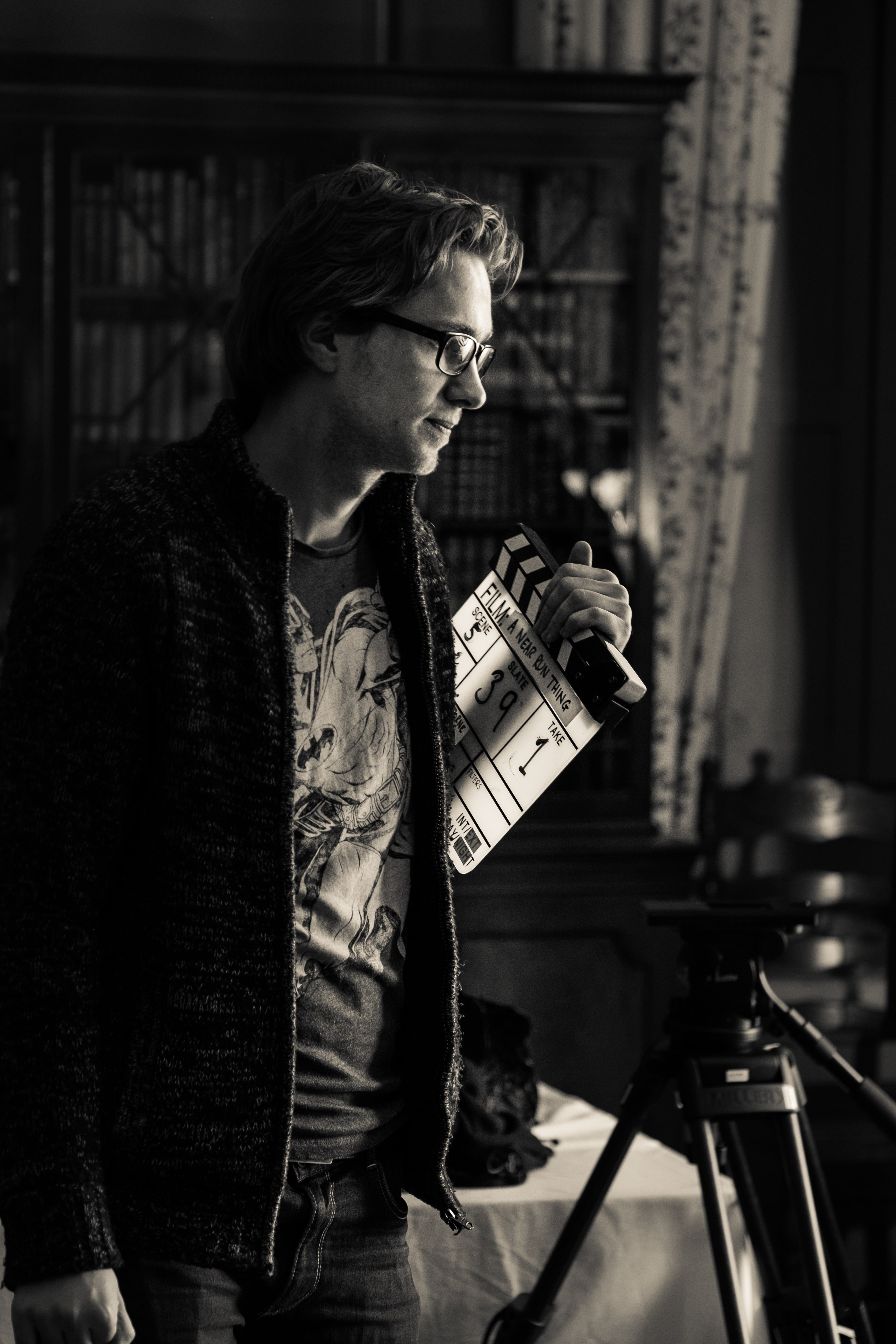 Man holding a film clapperboard during video production.