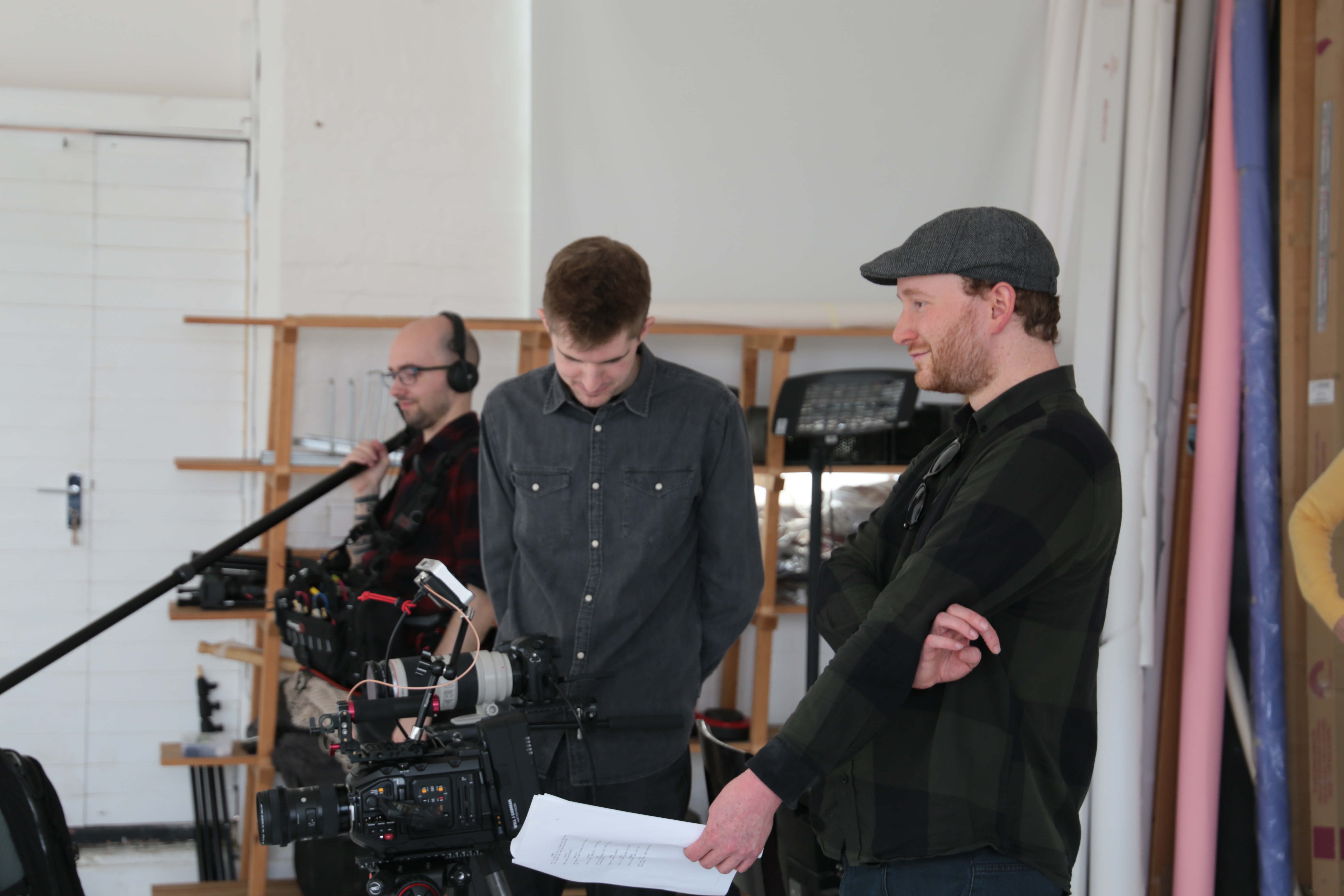 Film crew discussing with camera equipment on set.