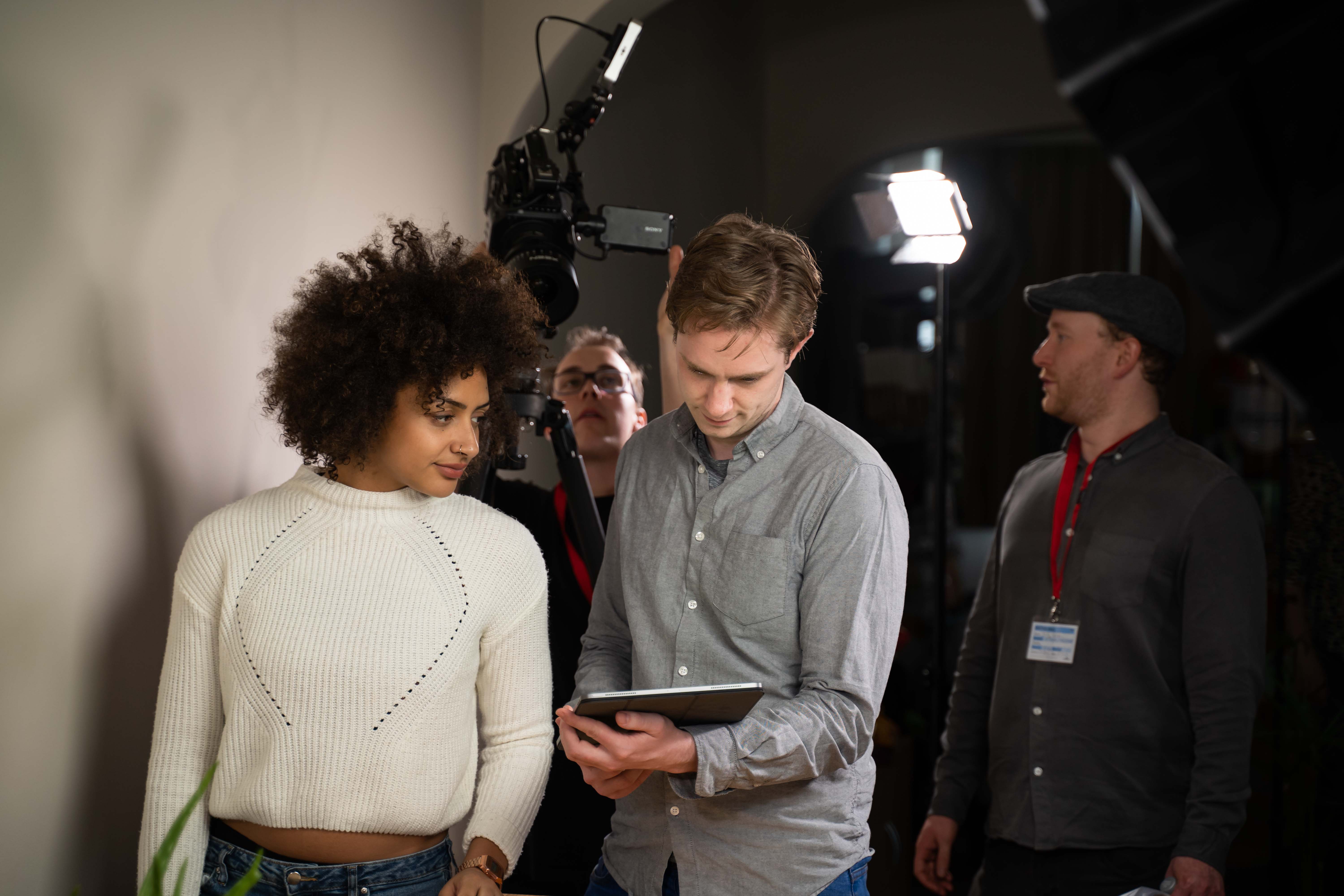 Video production crew directing actress on set.
