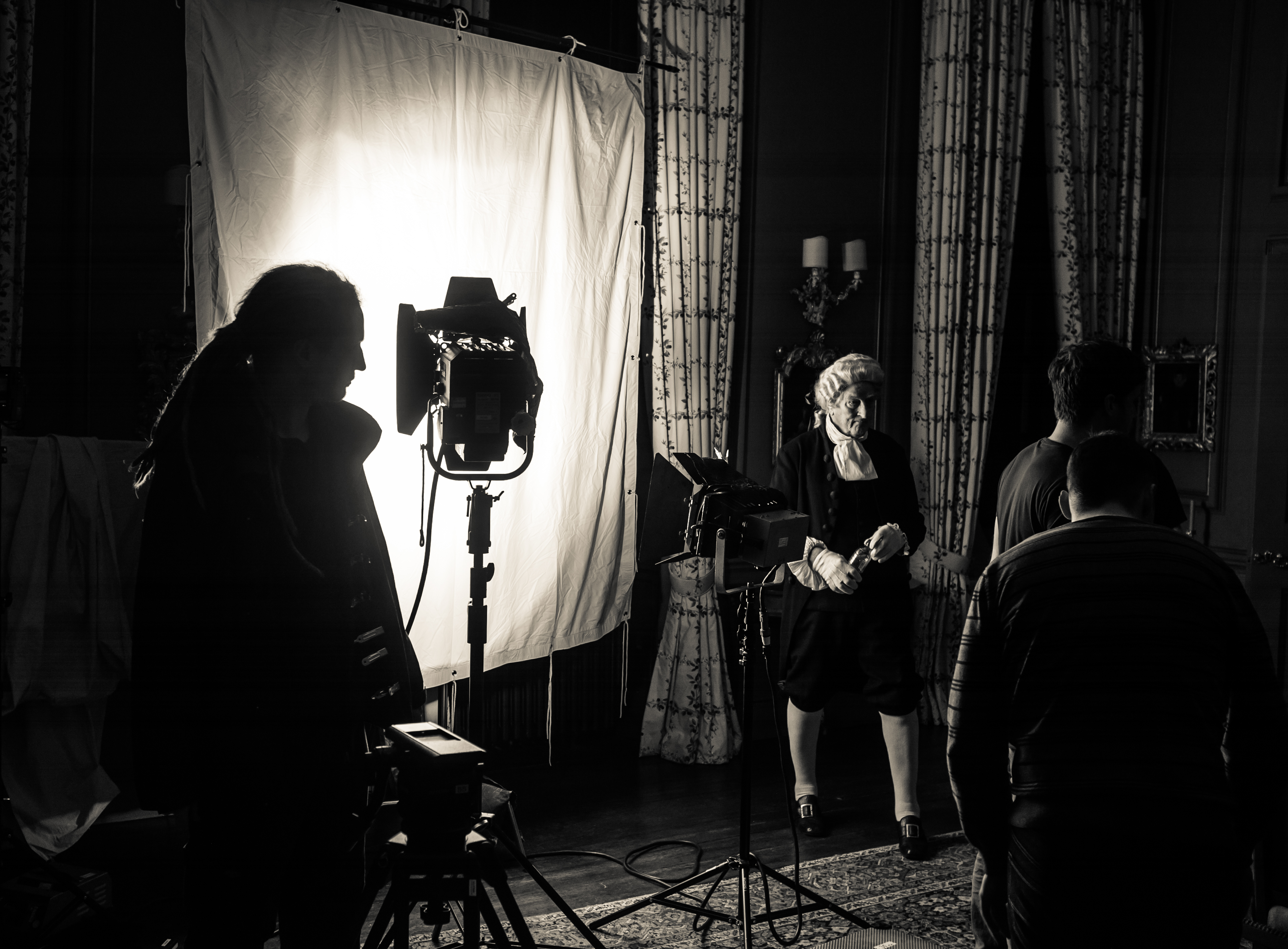 Film crew setting up lighting and equipment for a shoot.
