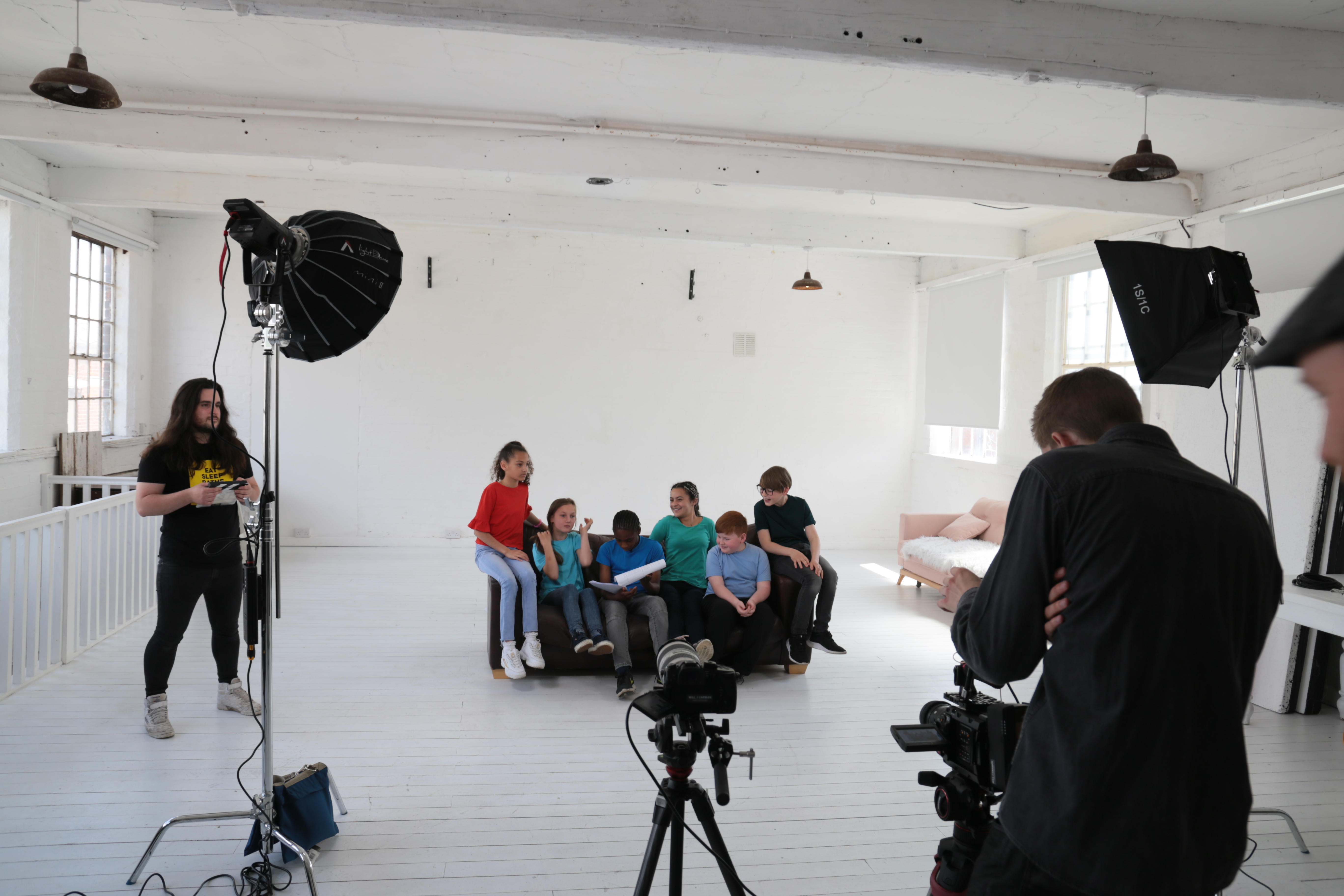Video shoot in a studio with cast and crew preparing for filming.
