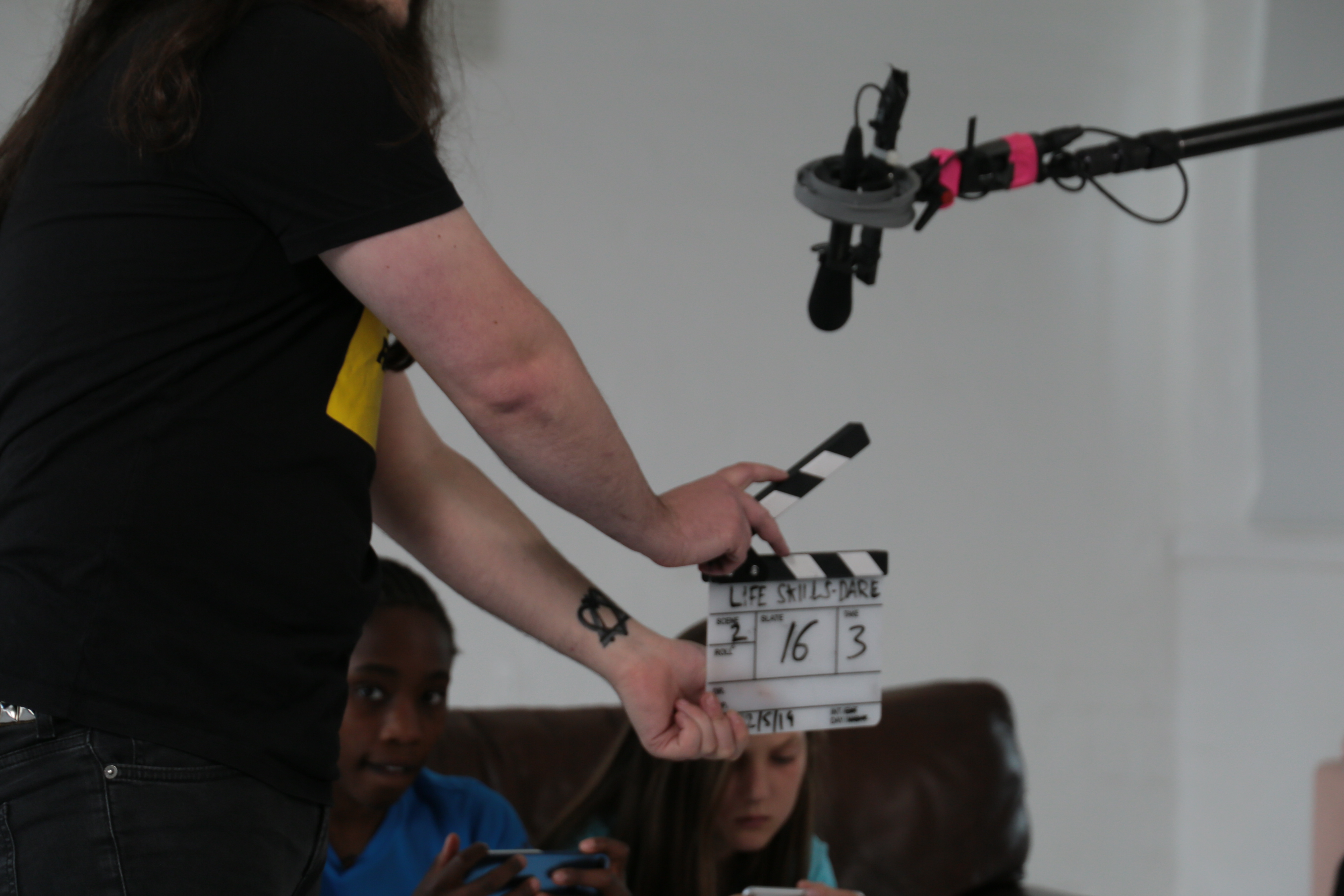 Crew member using a clapperboard on set while filming a scene for an impactful charity video.