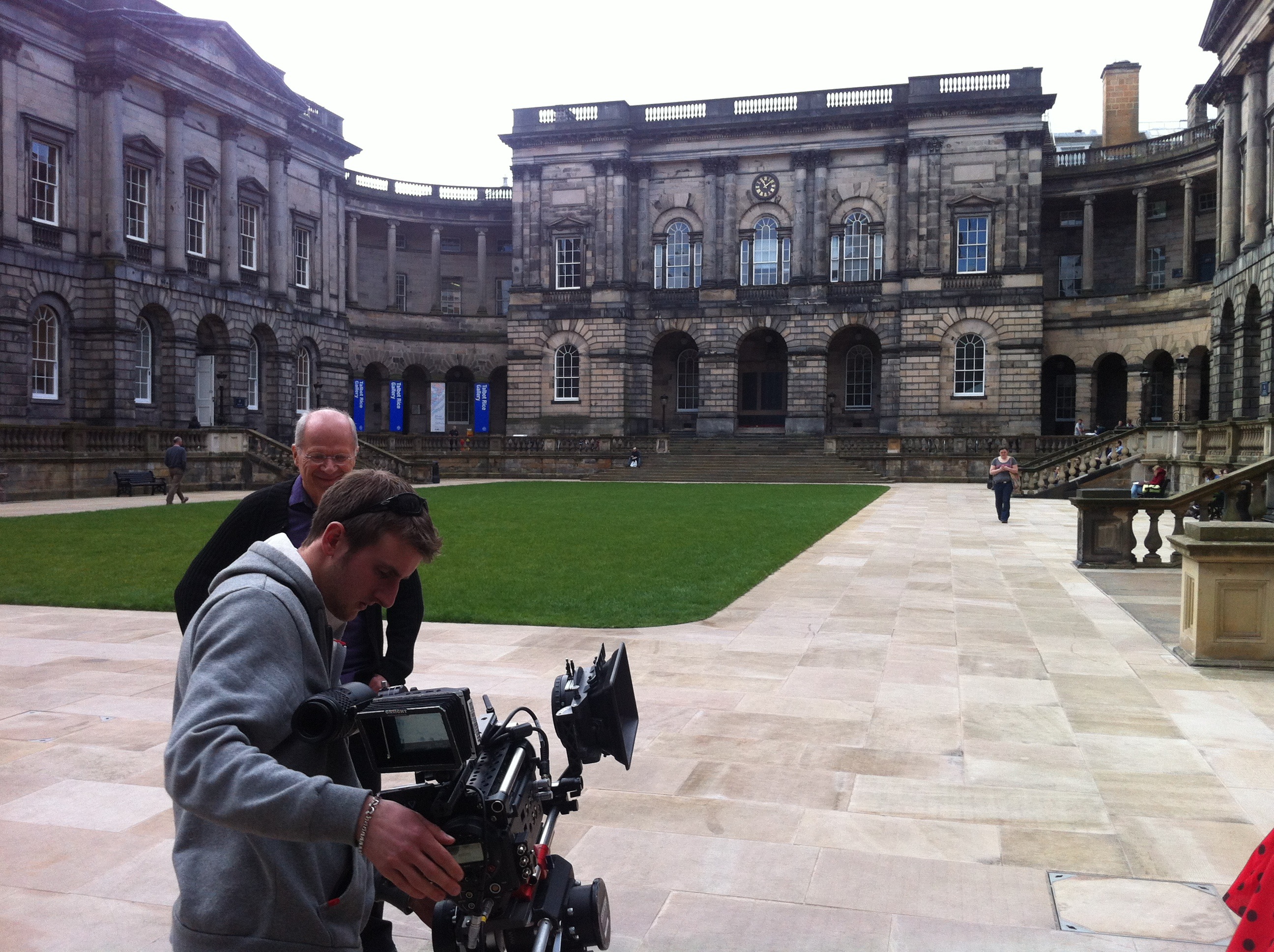 Film crew preparing camera equipment on location using on-site filming best practices.