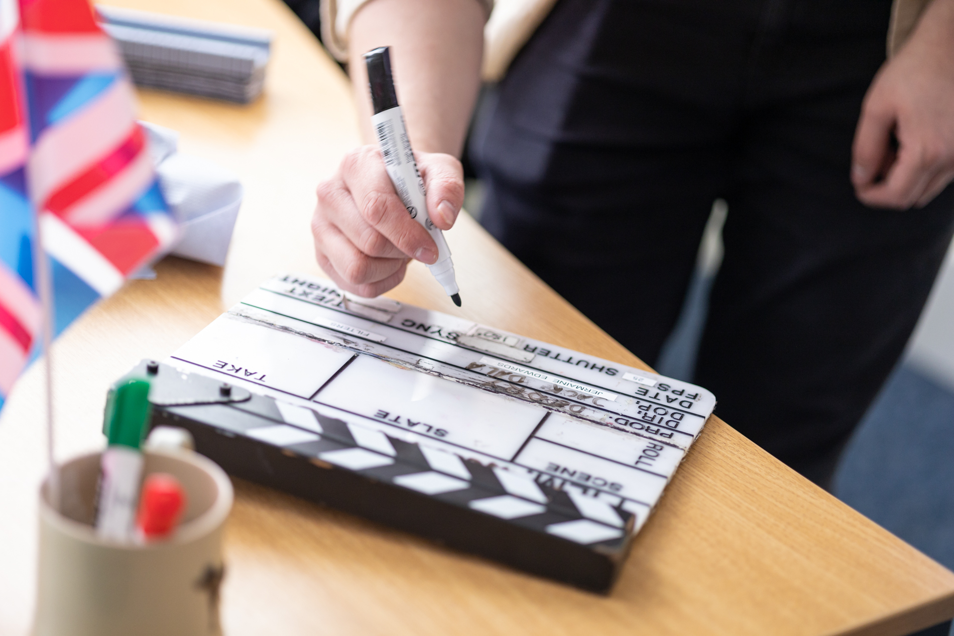Person holding a clapperboard during a video shoot, illustrating steps in a video marketing funnel.