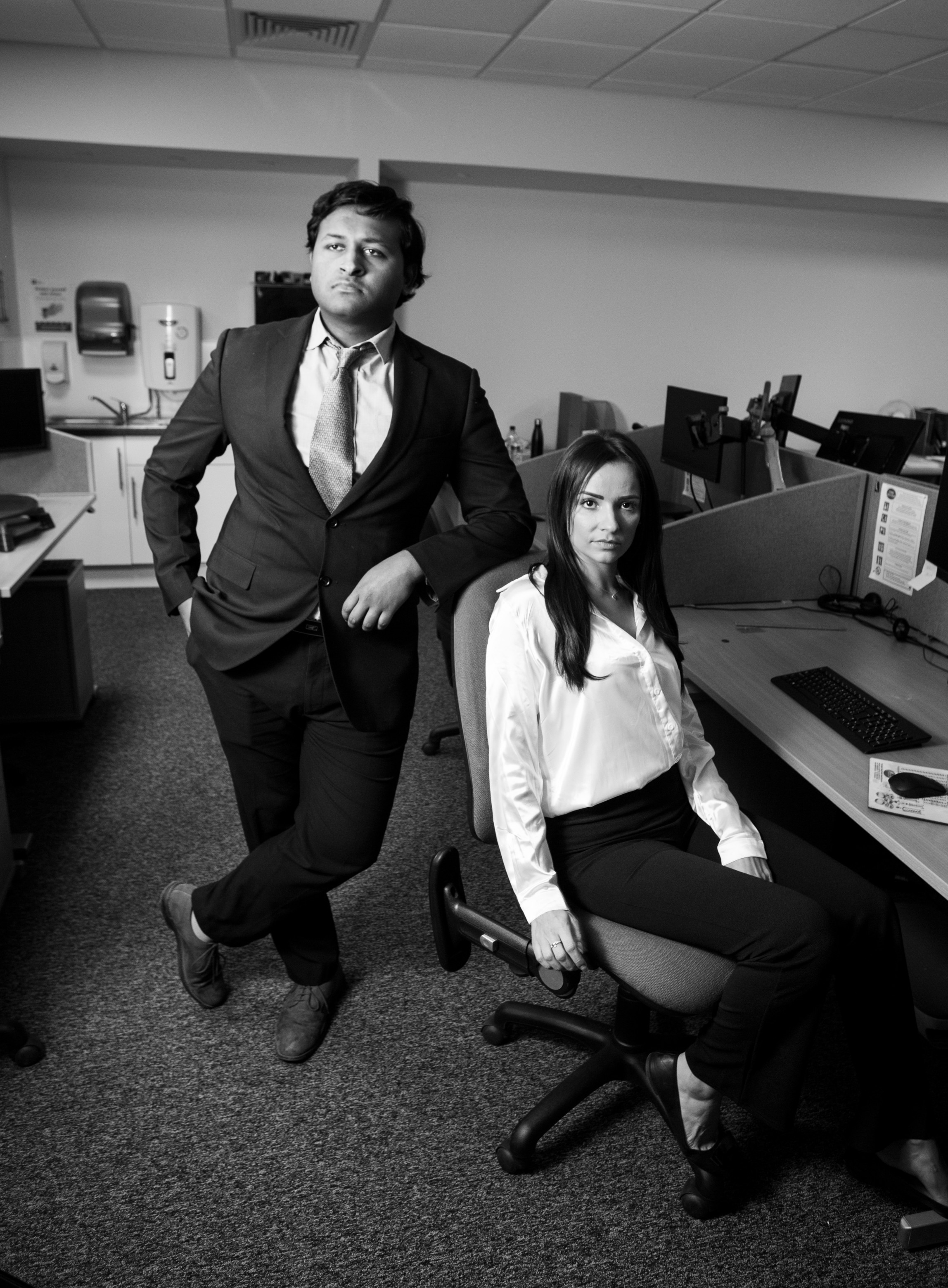 Two professionals in an office setting during a video production shoot.