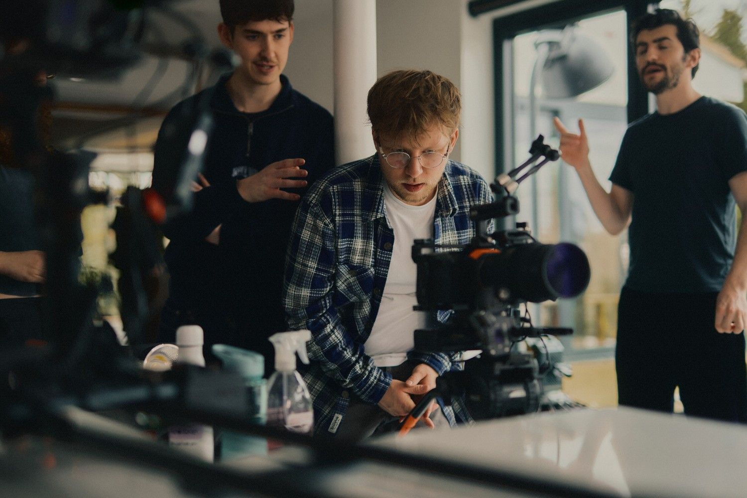Camera crew preparing equipment to shoot short form videos inside a studio setting.
