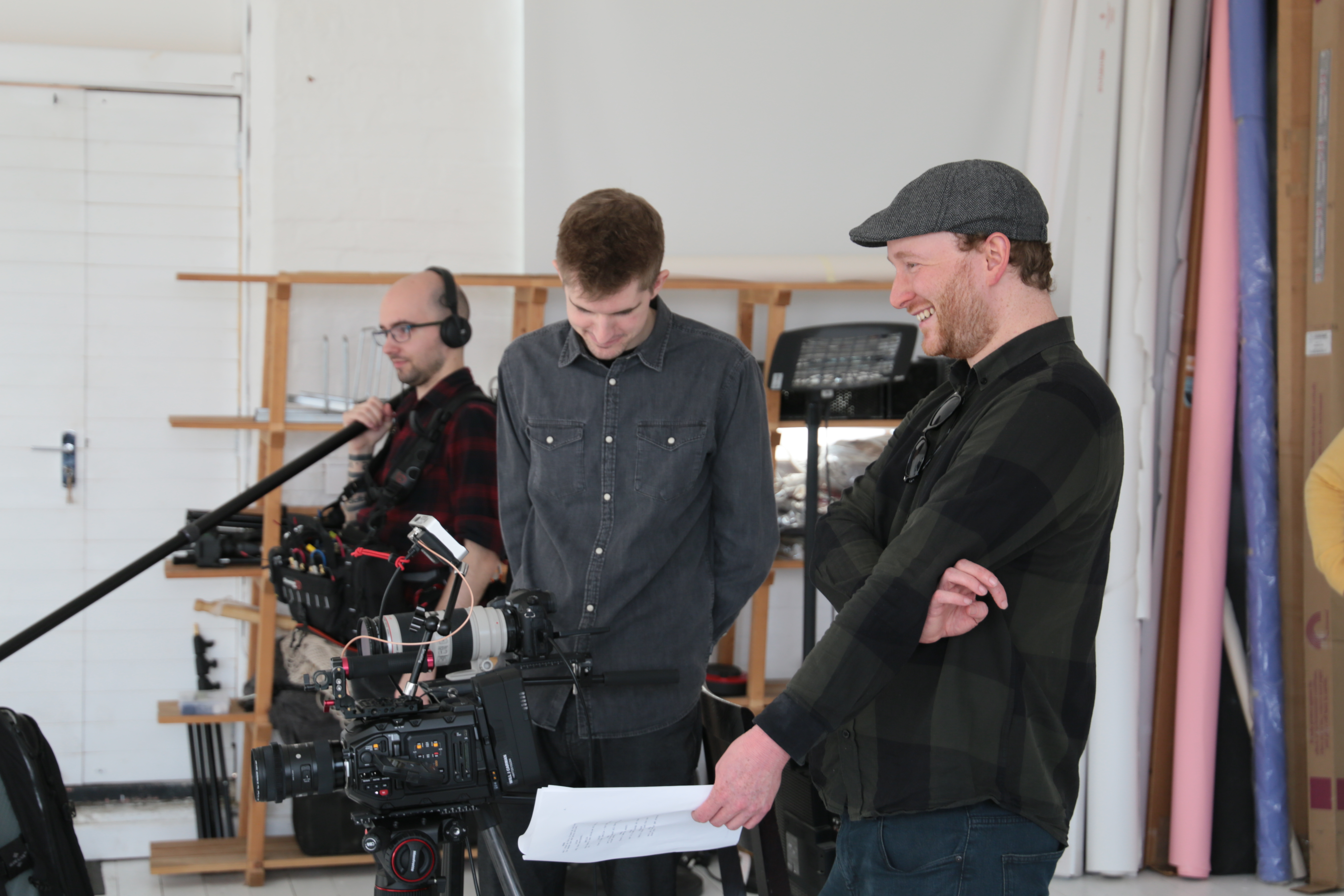 Video production team adjusting camera equipment during a studio shoot.