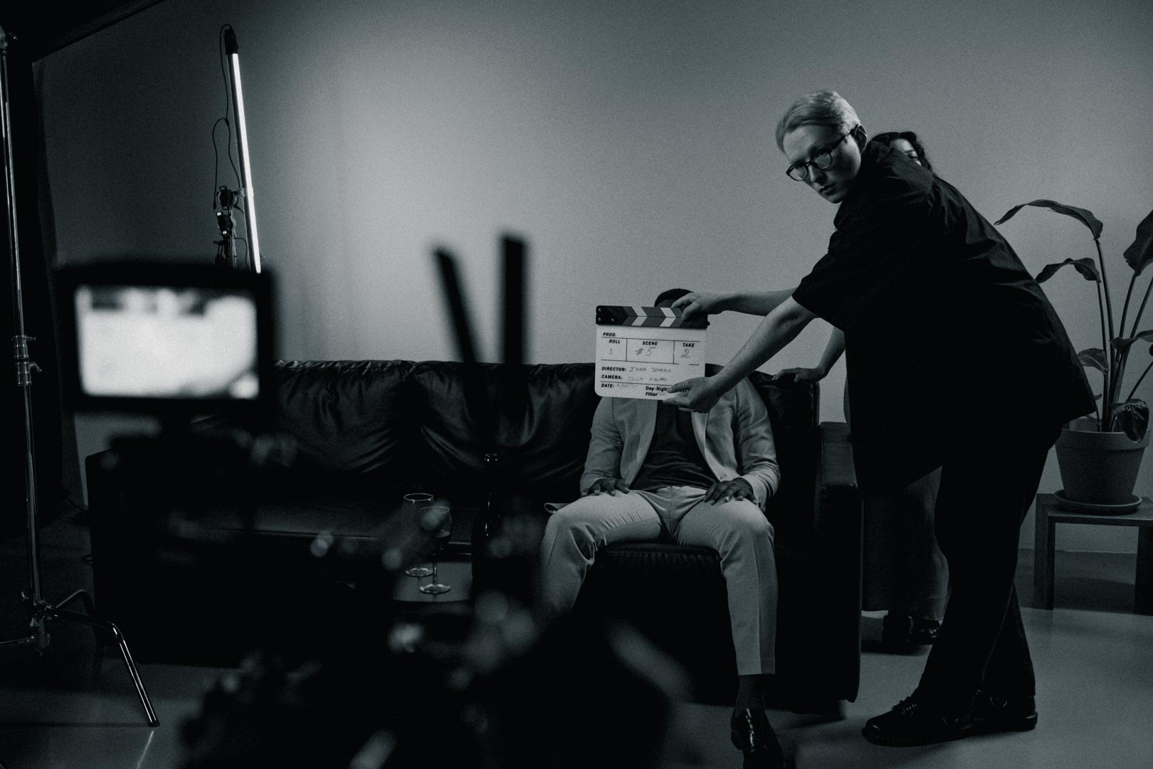 Film crew member holding a clapperboard on a corporate video production studio set