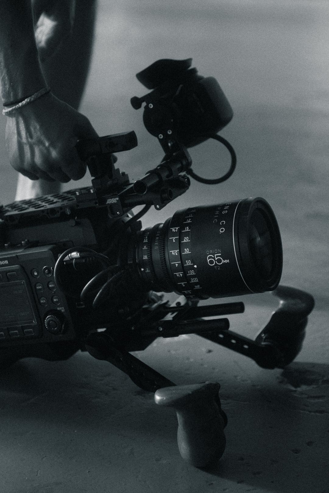 short and to the point alt text Videographer holding an ARRI cinema camera rig with a 65mm lens on a brand film shoot