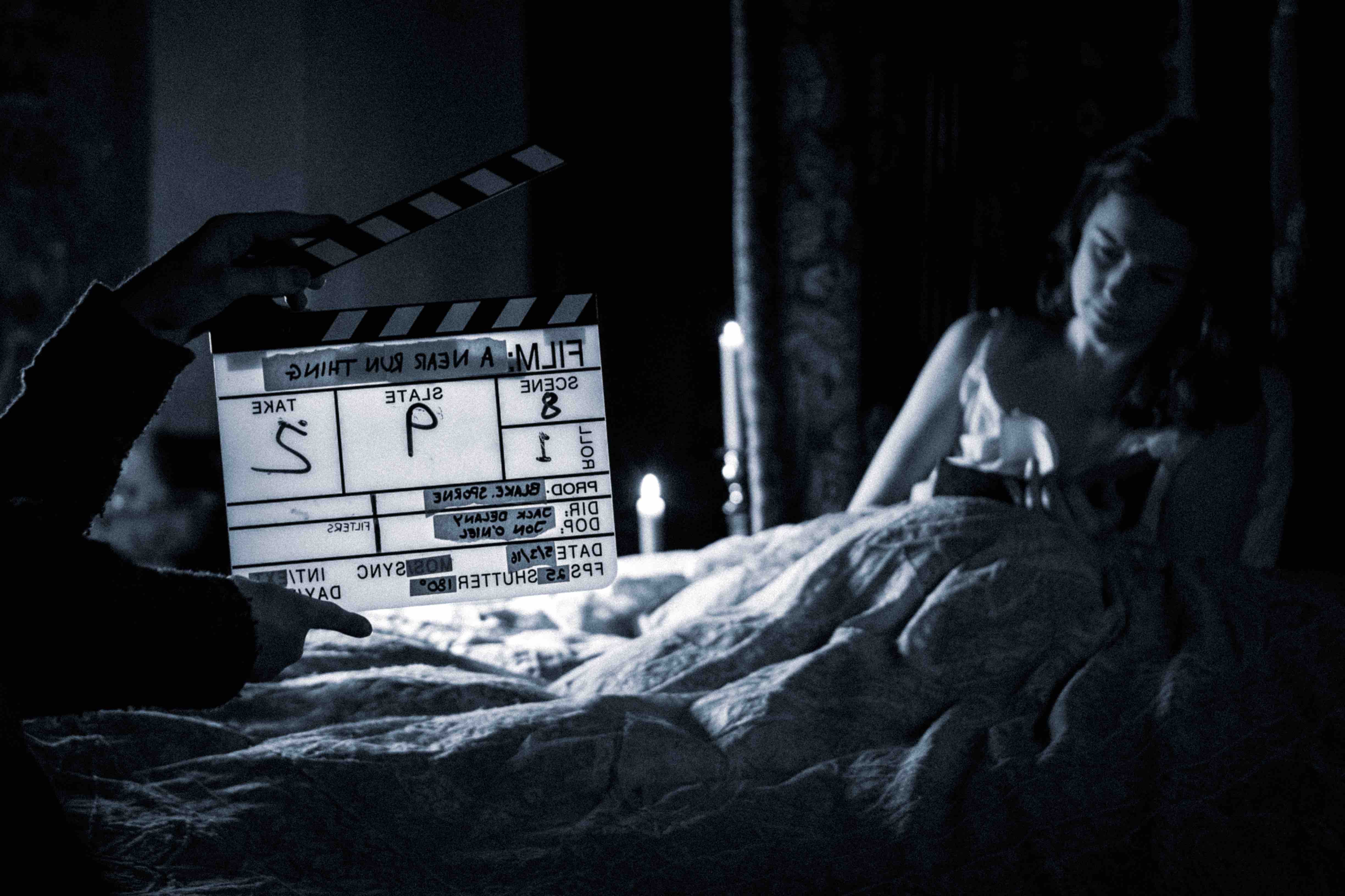 Clapperboard marking a scene during a brand film shoot with an actress in bed