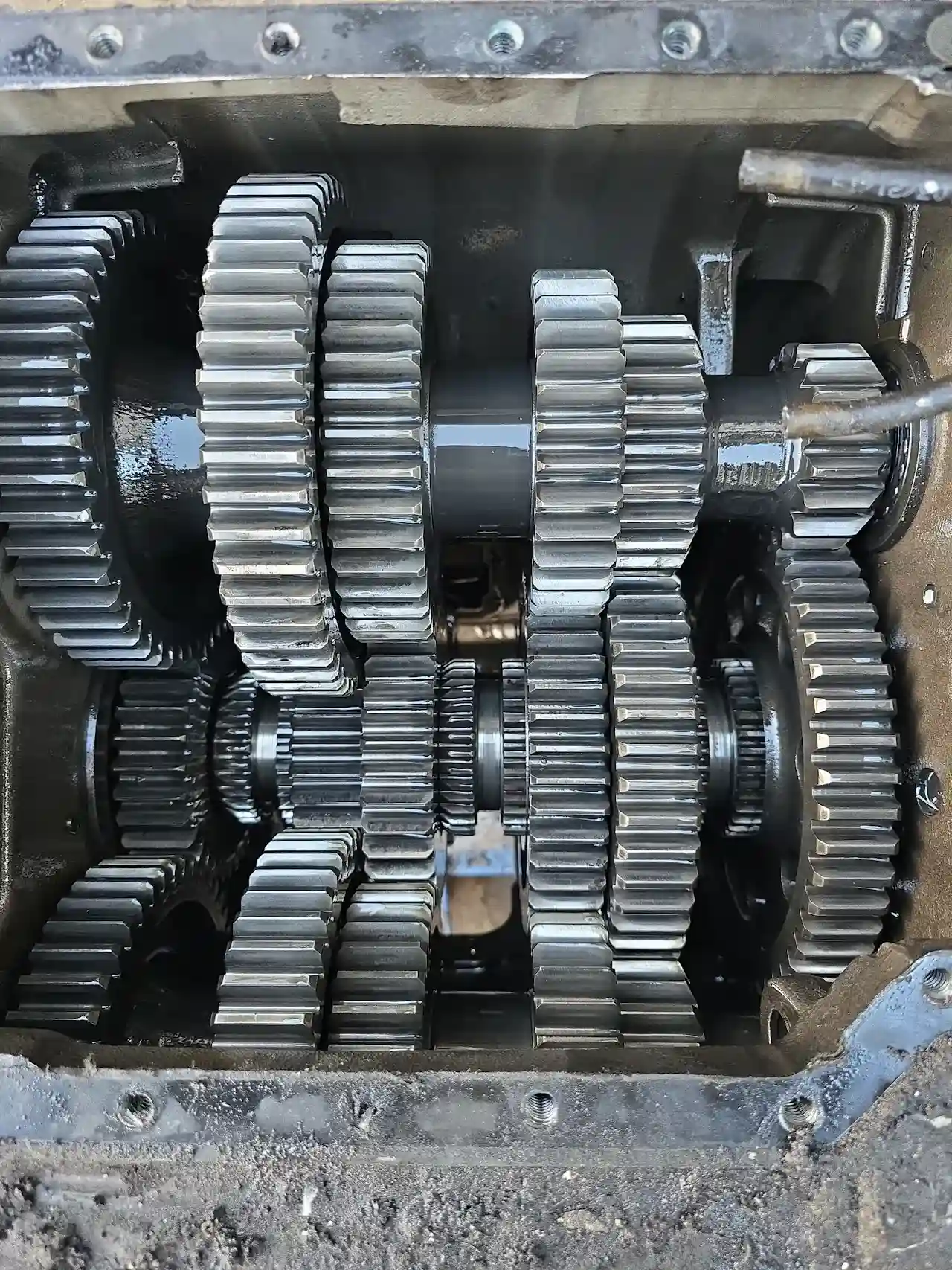 Transmission problems showing exposed heavy-duty gearbox with interlocking gears and visible wear inside housing.