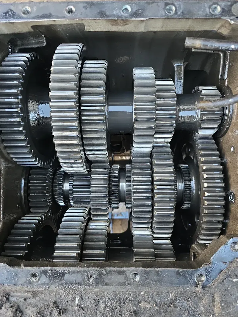 Transmission problems showing exposed heavy-duty gearbox with interlocking gears and visible wear inside housing.