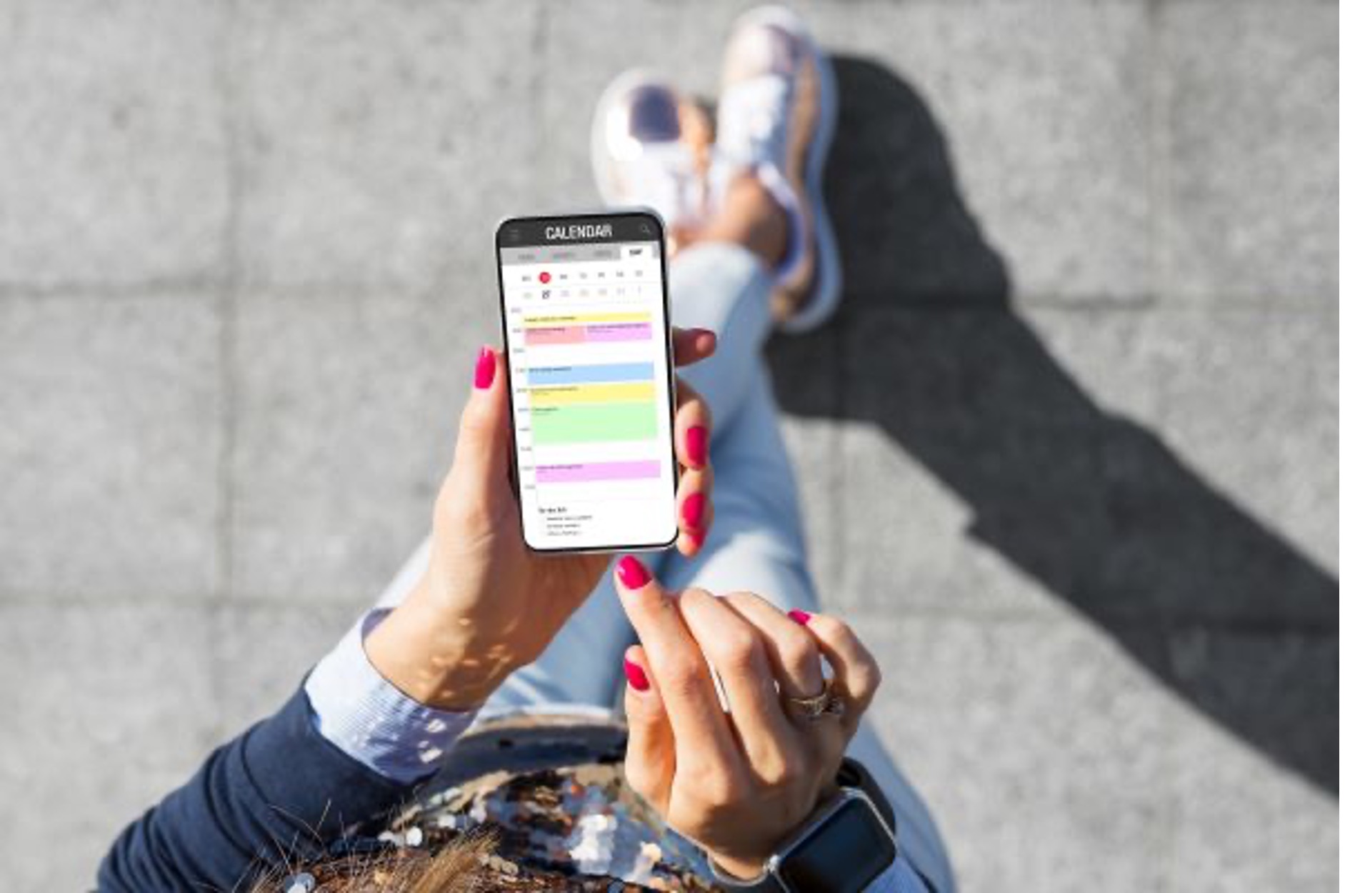 woman looks down at the calendar on her phone