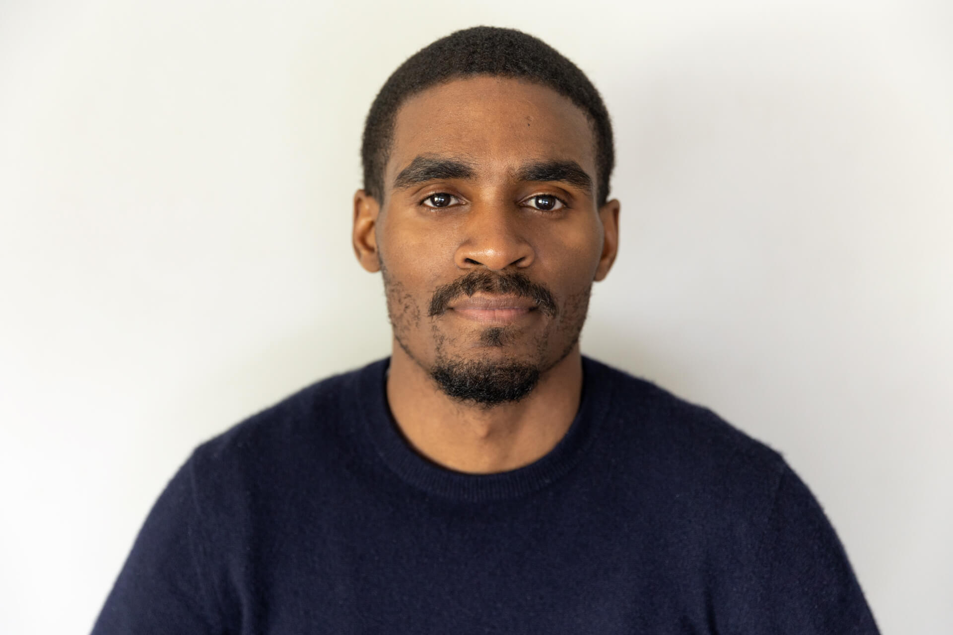 An image of a young-African male posing for a headshot.