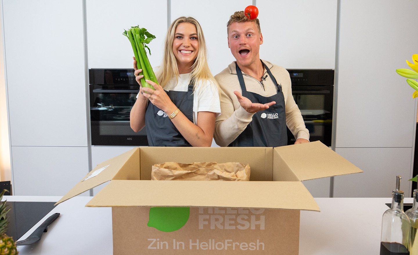 Two creators unpacking a HelloFresh box in a kitchen