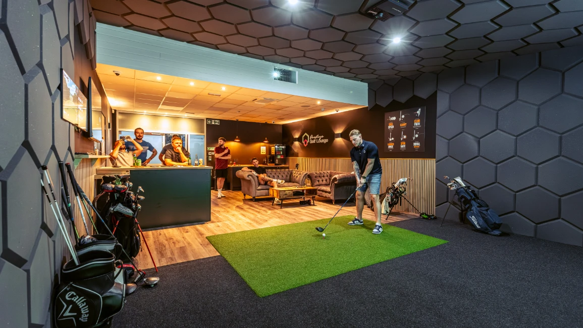 Indoor golf simulator at Prestige Golf Lounge with players and friends enjoying the lounge atmosphere