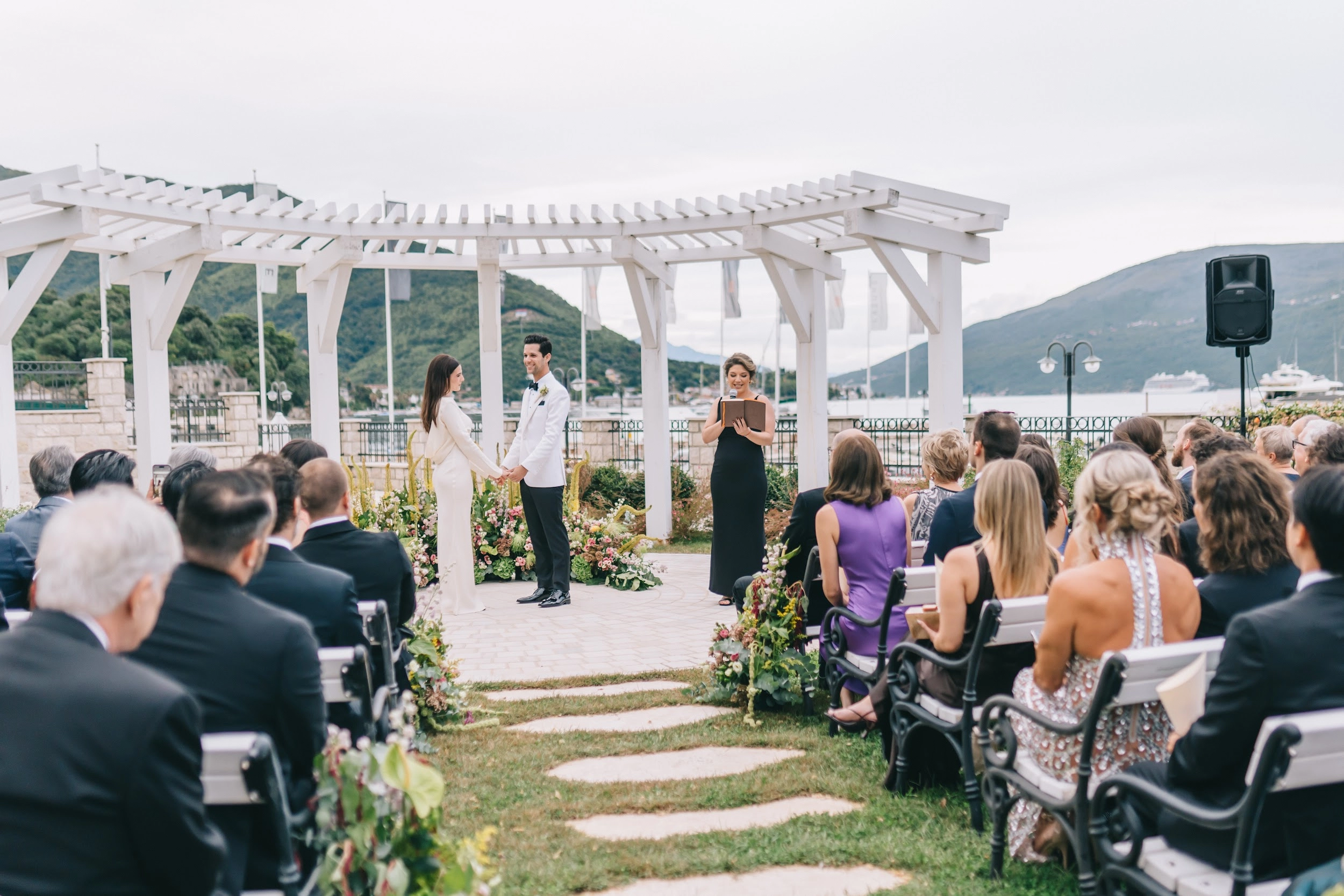 SHowing wedding shots, couple waliking togeter on the edge of ocean and dancing