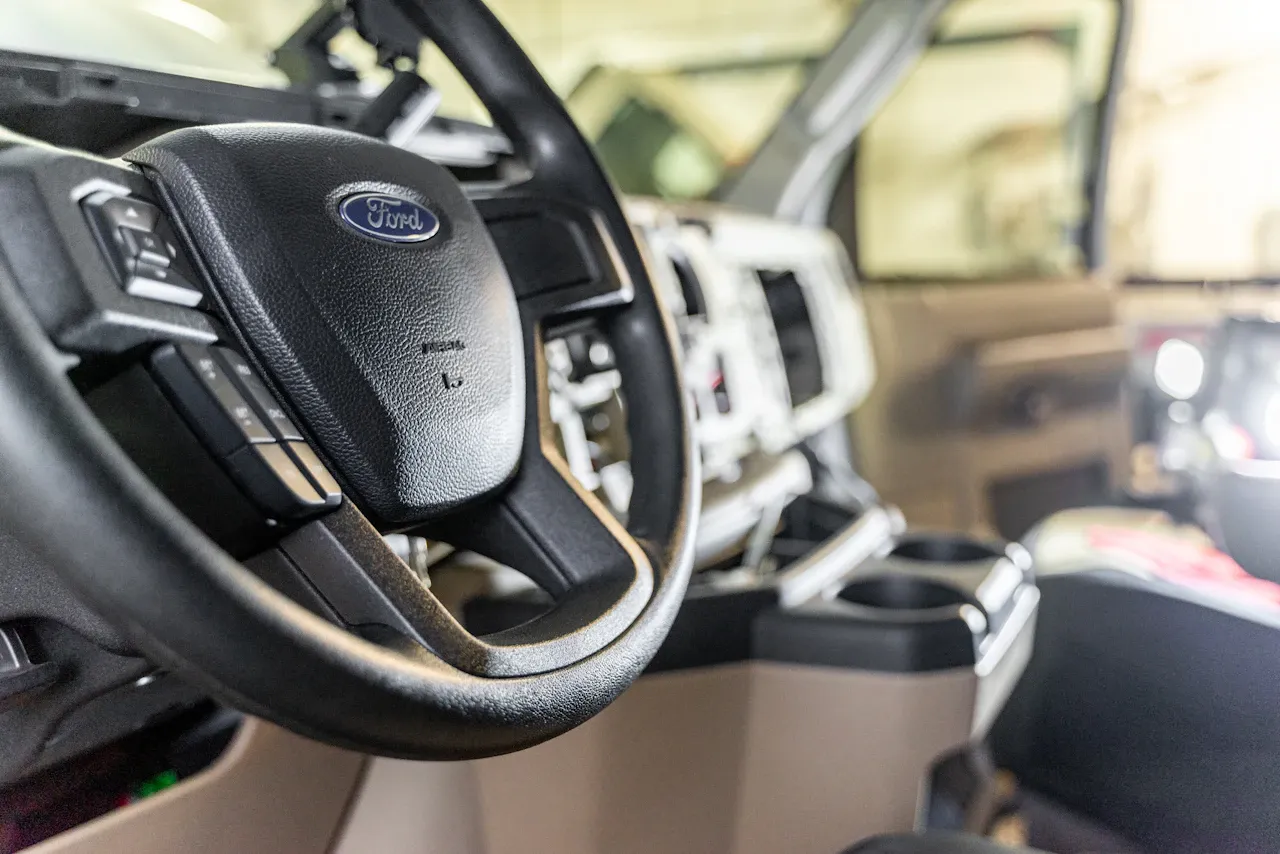 Fleet vehicle interior showing a Ford steering wheel and dashboard during heavy-duty service.
