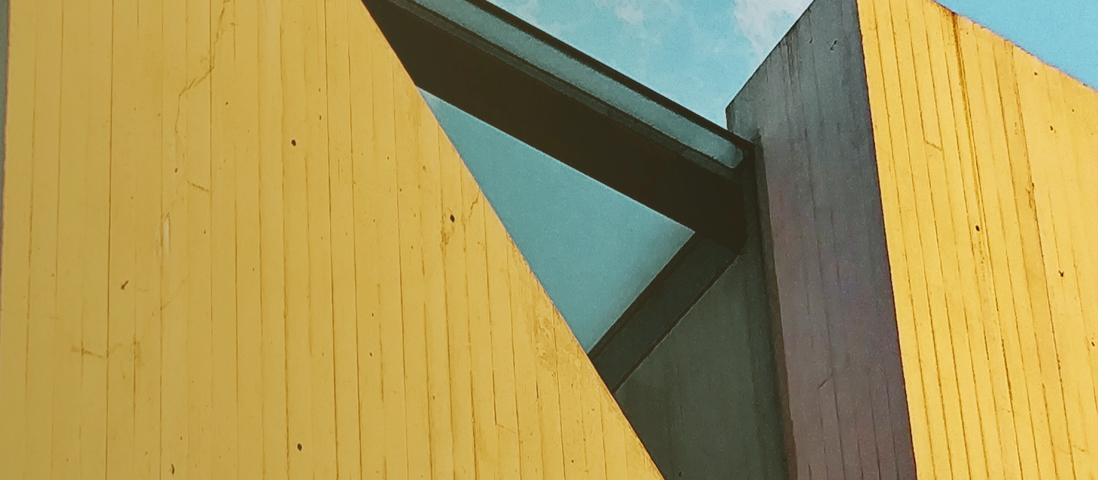 A building with yellow walls and blue and black windows.