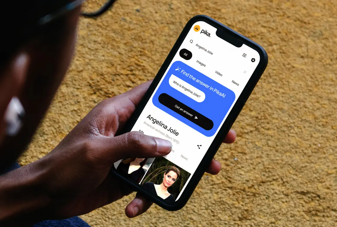 A person holding a mobile phone showing AI-driven product.