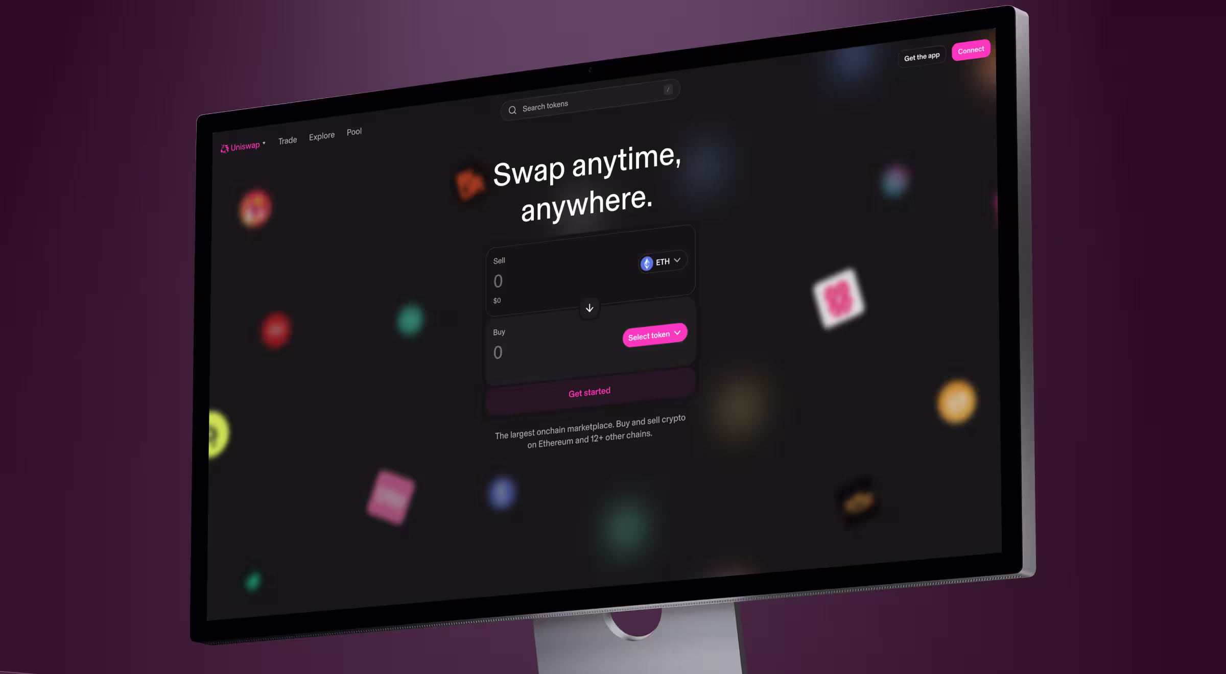 A computer monitor displays the Uniswap crypto trading interface with the tagline “Swap anytime, anywhere.” The UI features a dark theme with a token swap module centered on the screen and colorful token icons floating in the background.