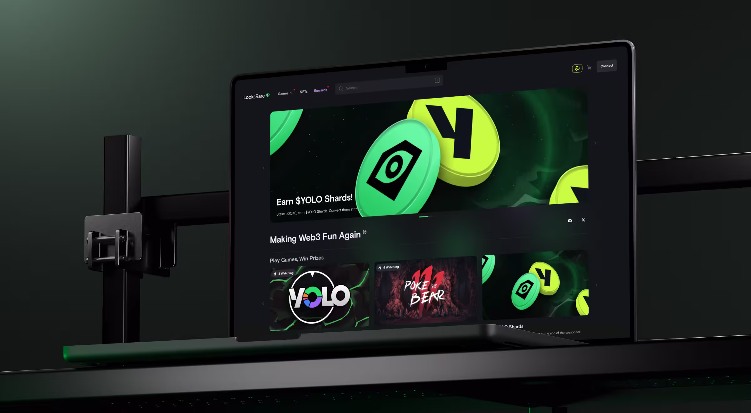 A dark-themed laptop screen shows the LooksRare platform promoting Web3 games and rewards like $YOLO Shards. Bright green and yellow tokens dominate the header, while games like “Poke the Bear” and “YOLO” appear below.
