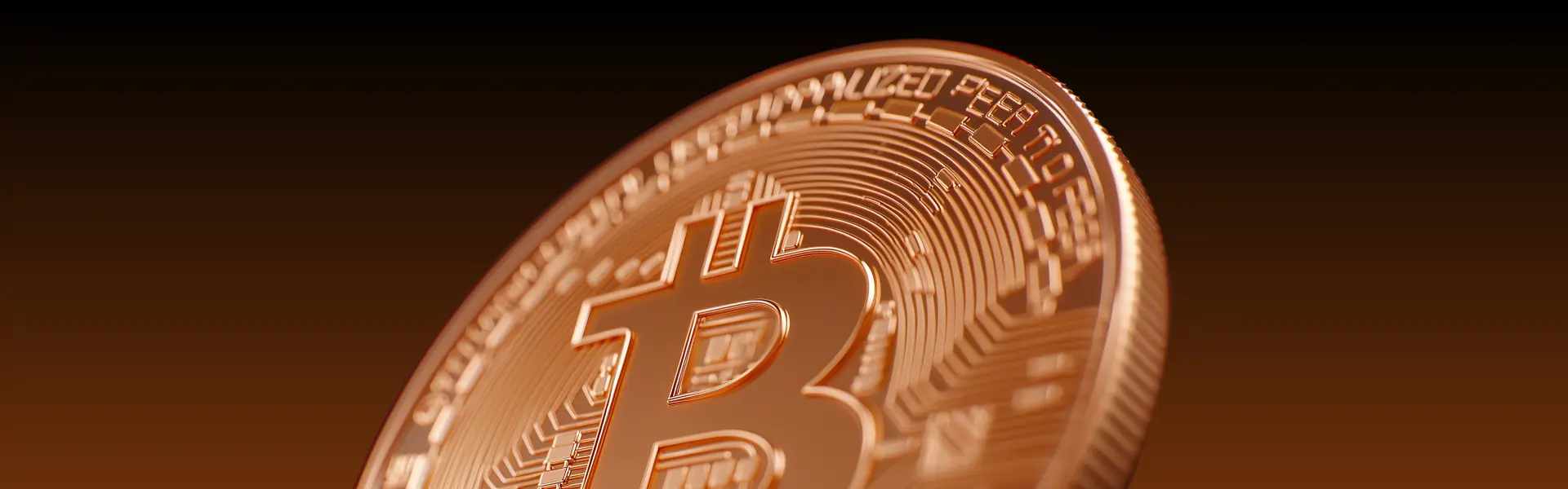 Close-up image of a shiny, gold-toned Bitcoin coin featuring the iconic "₿" symbol and intricate circuitry patterns, set against a warm gradient background.
