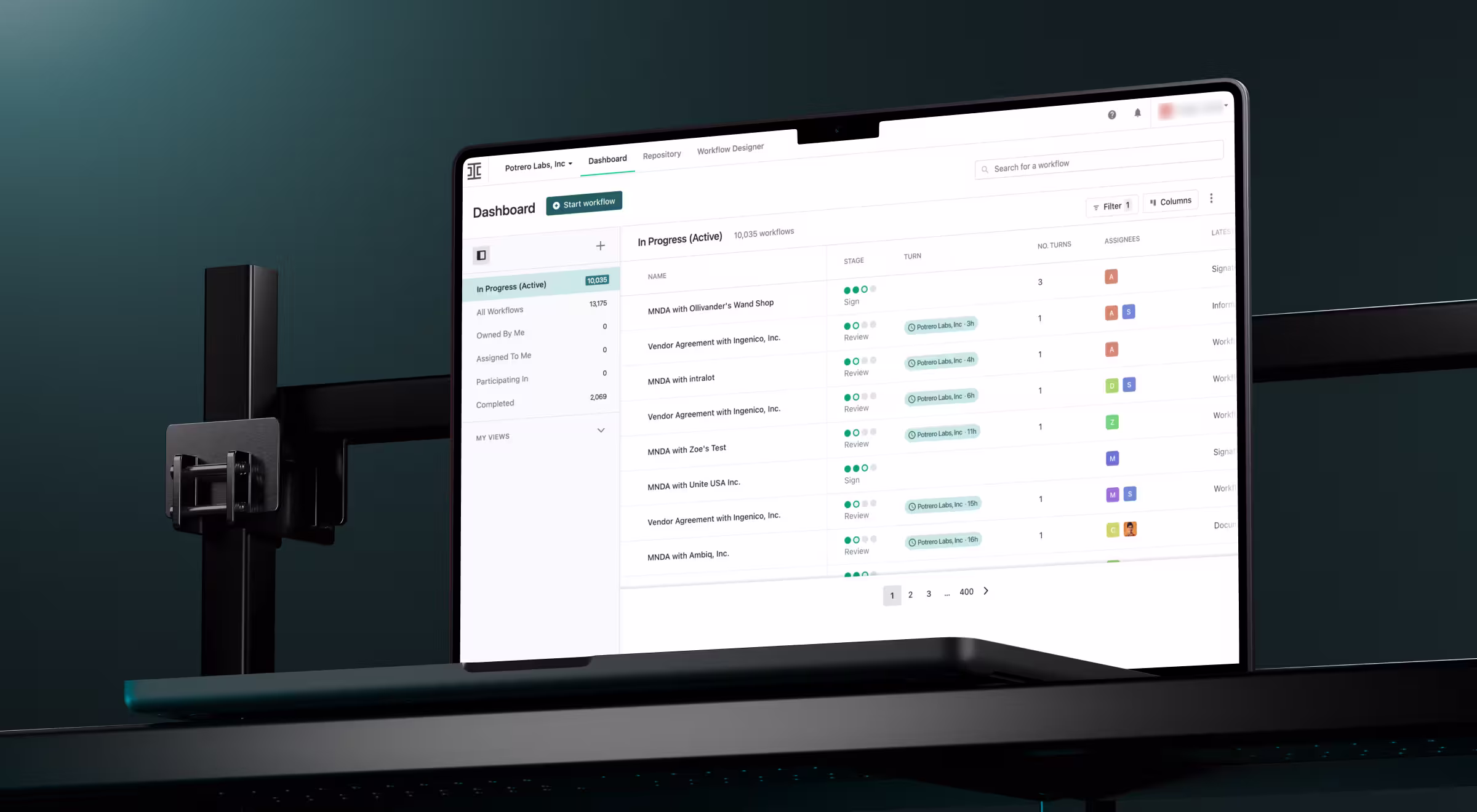 A legal workflow dashboard is shown on a laptop screen, displaying a list of agreements and contracts with status labels like “Sign” and “Review.” The interface supports task tracking, assignee visibility, and filtering across multiple workflows.